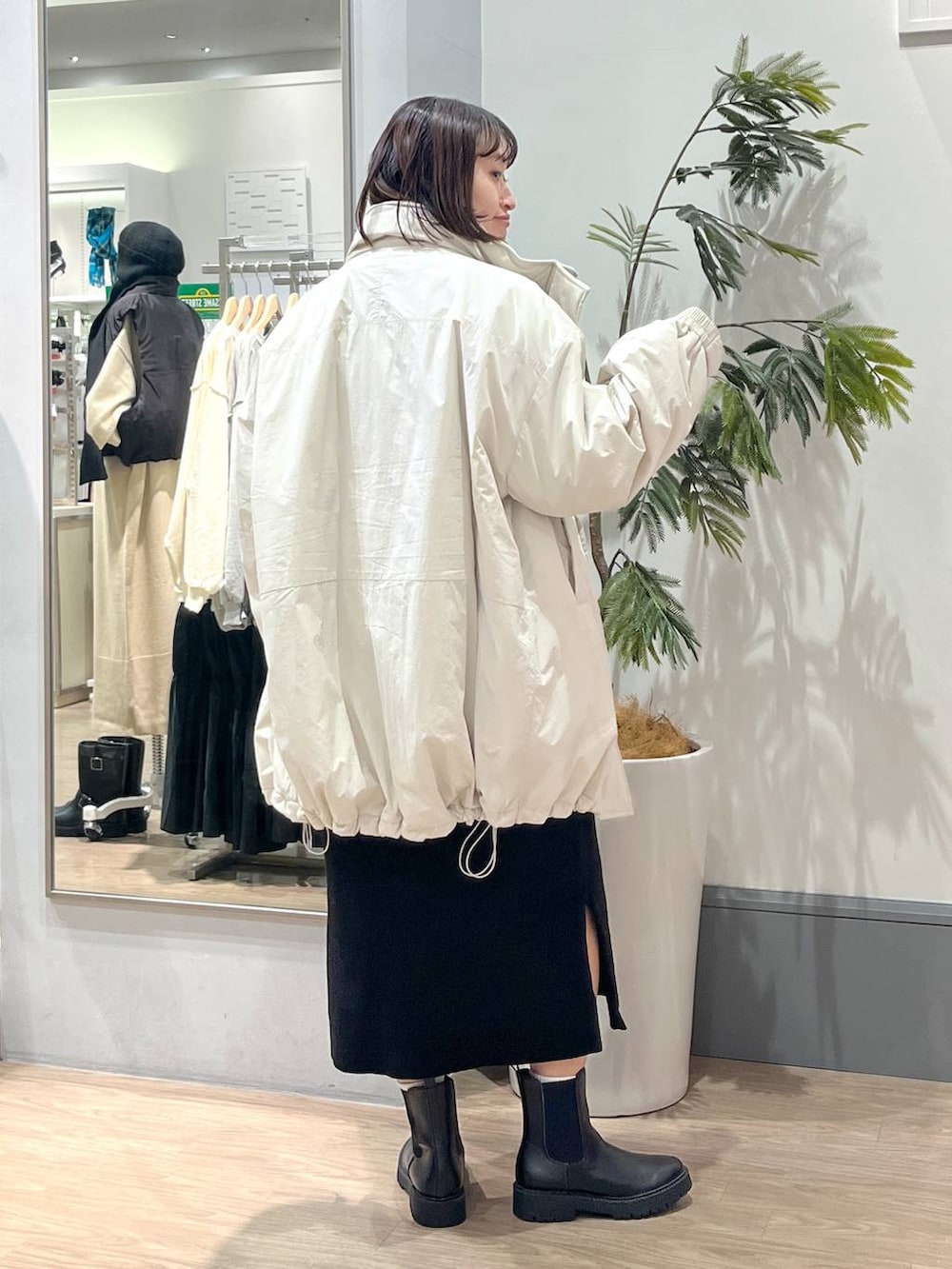 ホワイト系のその他アウター、ブラック系のブーツ、ブラック系のワンピースを着用したレディースの秋コーディネートの4枚目の写真