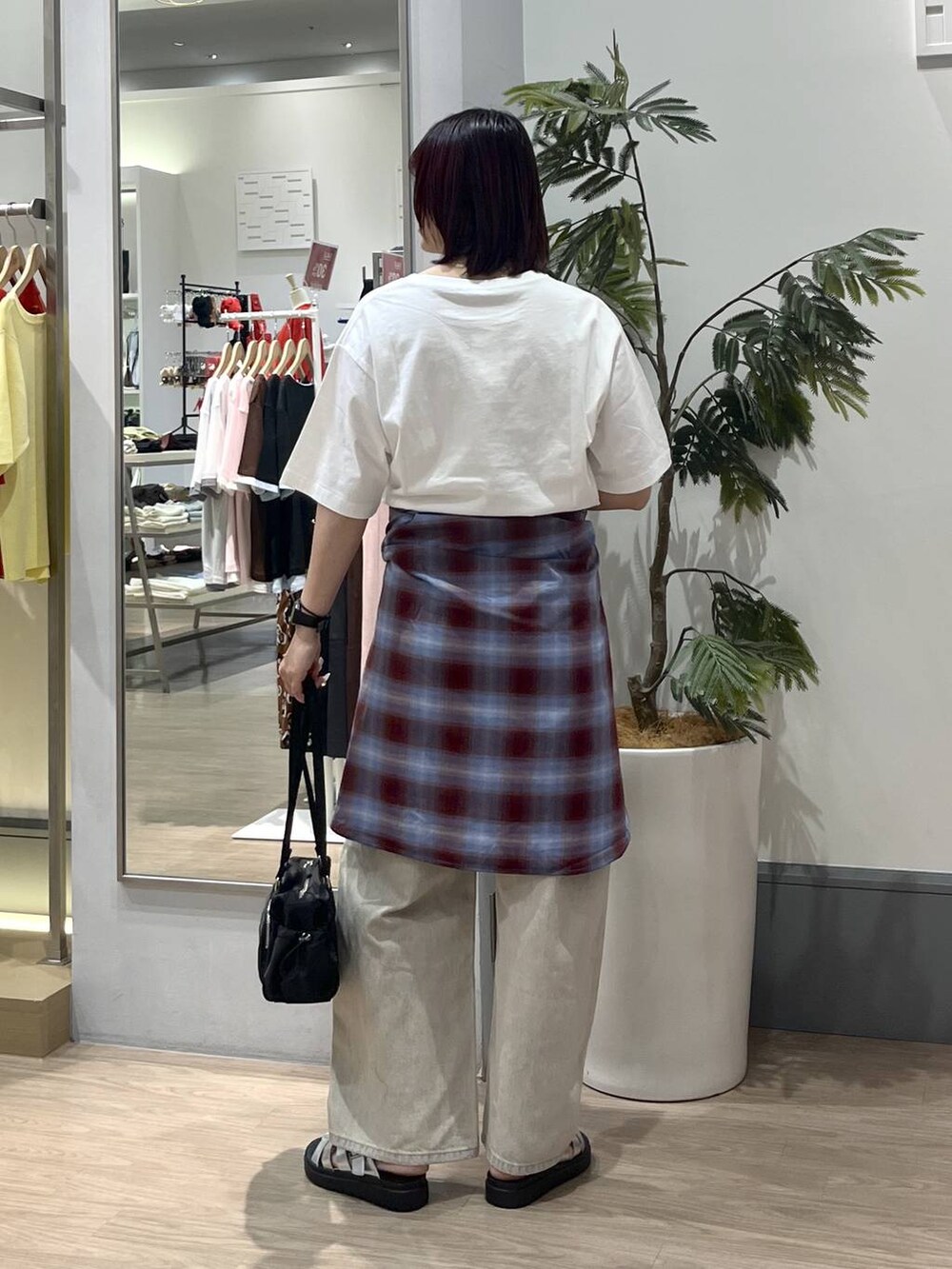 ベージュ系のデニムパンツ、シルバー系のサンダル、ブラック系のボストンバッグを着用したレディースの夏コーディネートの4枚目の写真