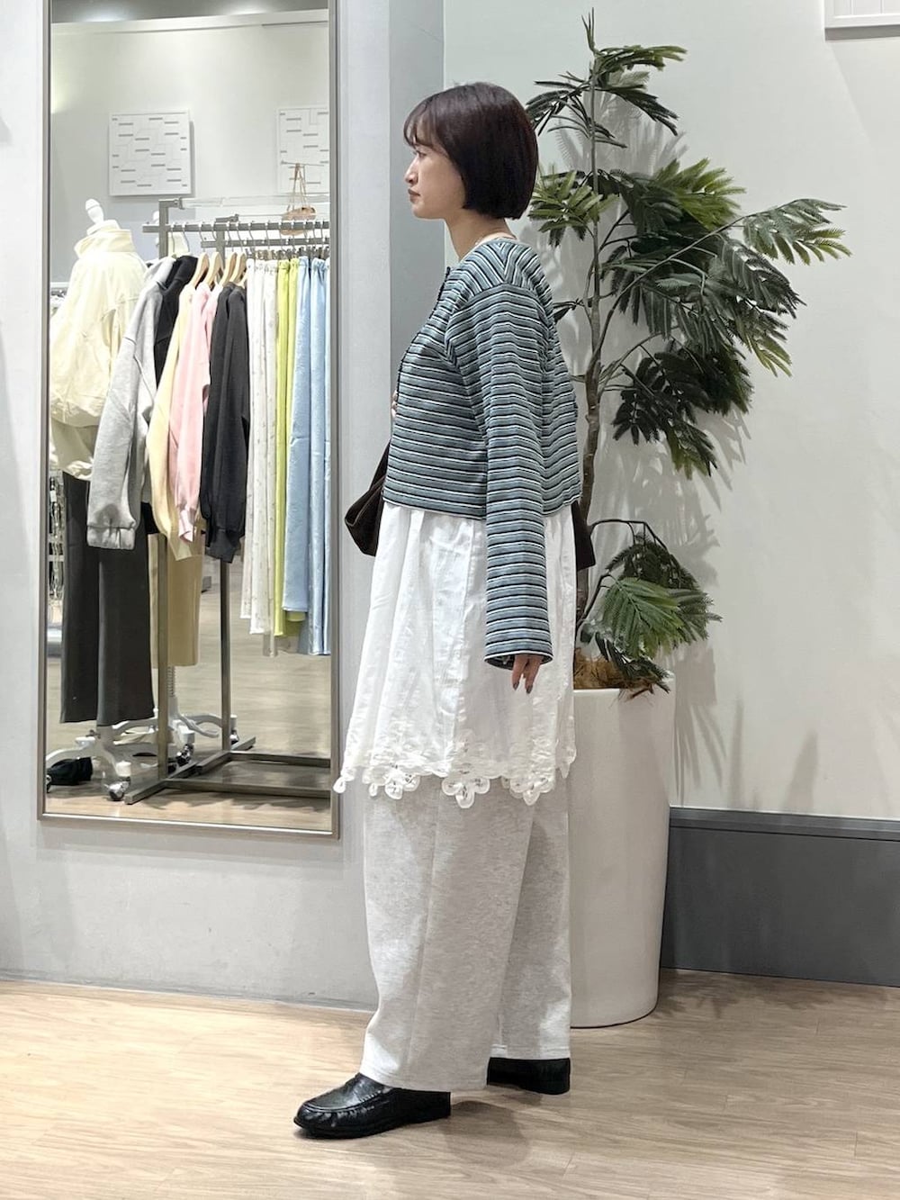 ブラック系のTシャツ/カットソー、グレー系のスウェットパンツ、ブラック系のローファーを着用したレディースの春コーディネートの3枚目の写真