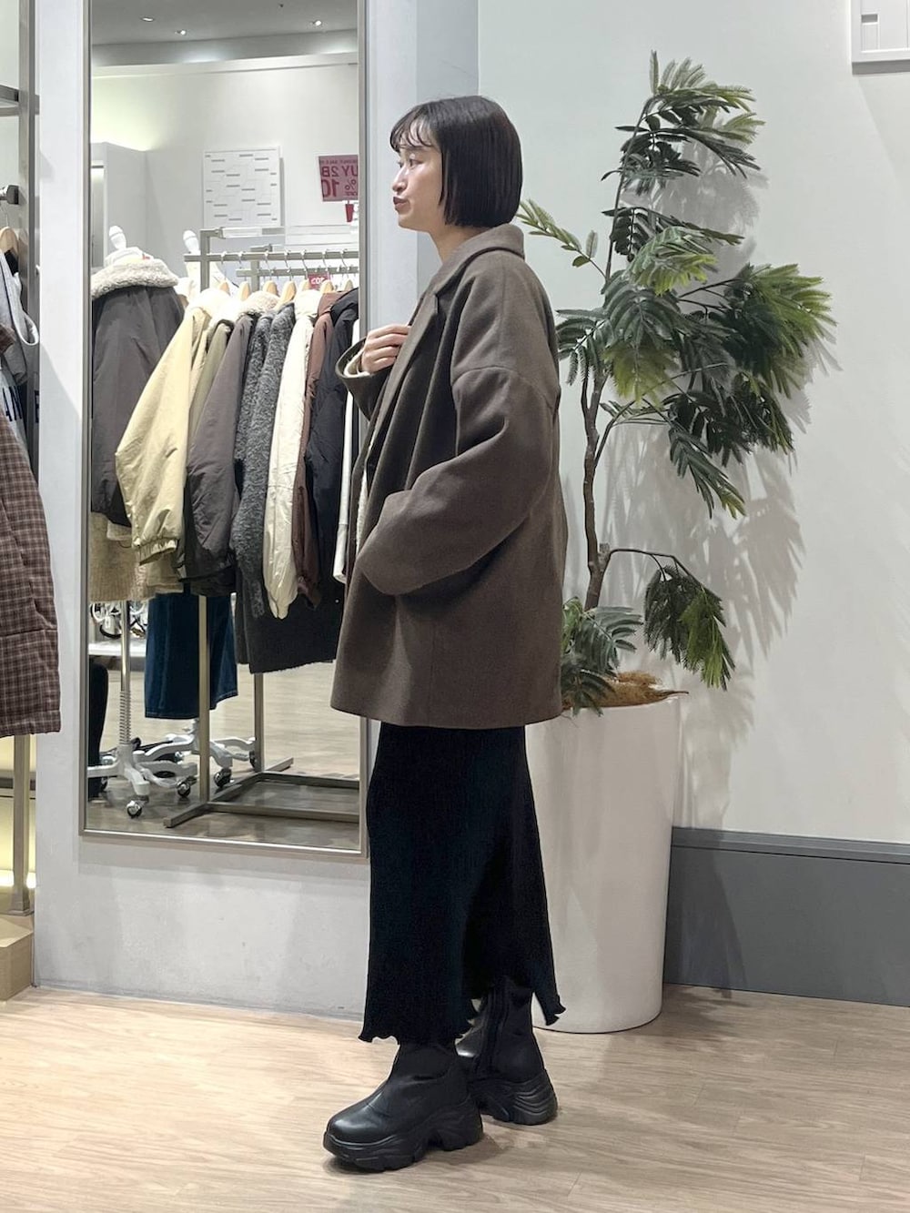 ホワイト系のニット/セーター、ブラック系のブーツ、ブラック系のスカートを着用したレディースの冬コーディネートの3枚目の写真