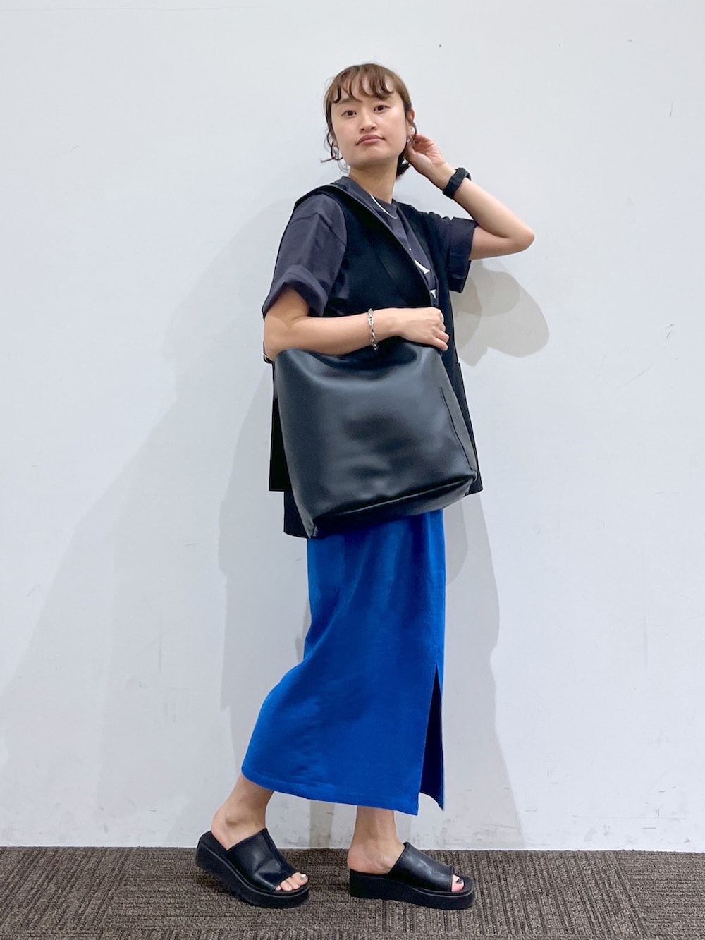 グレー系のTシャツ/カットソー、ブラック系のベスト、ブラック系のシューズを着用したレディースの夏コーディネートの2枚目の写真