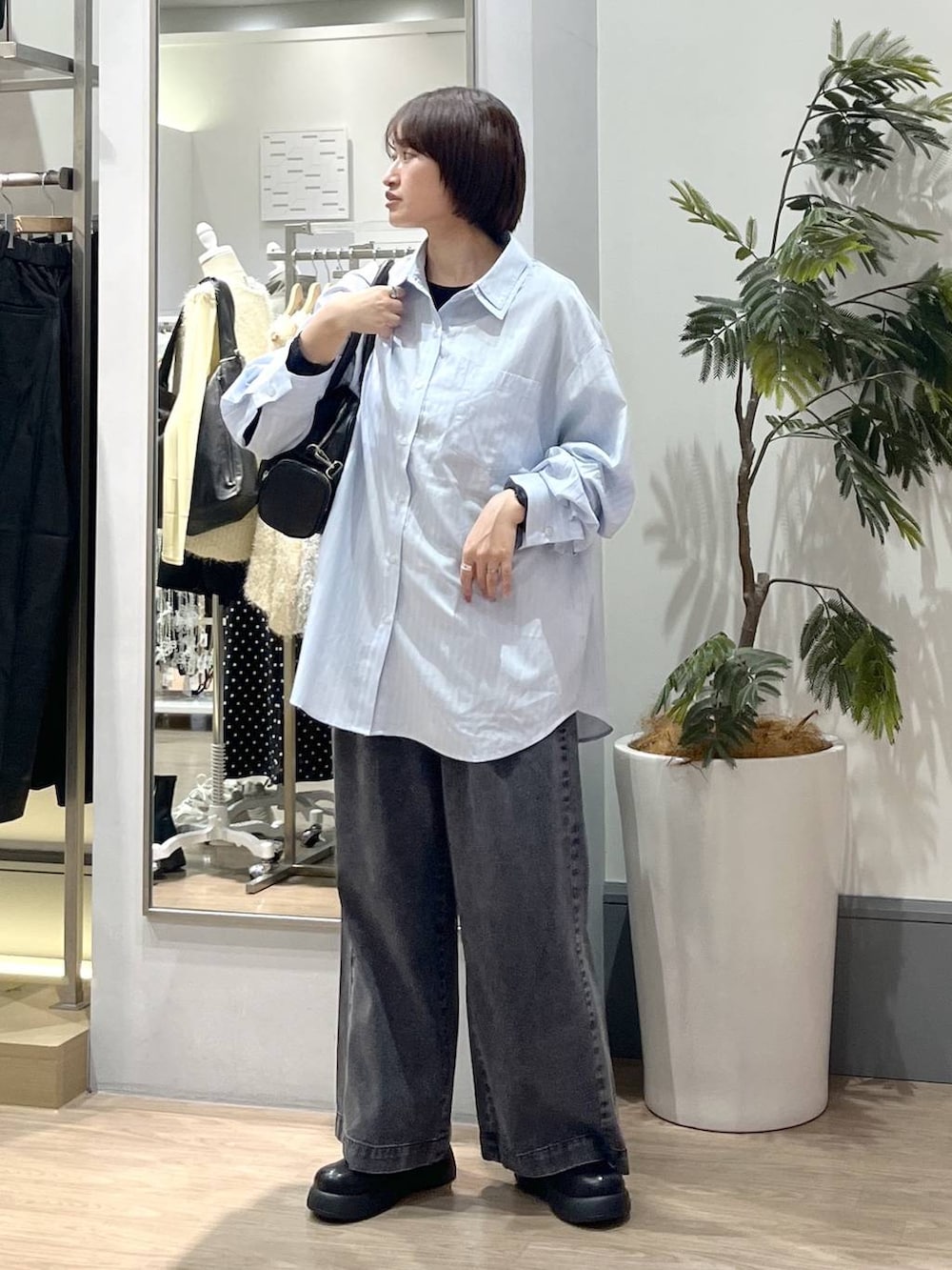 ブラック系のデニムパンツ、ブラック系のボストンバッグ、ブラック系のサンダルを着用したレディースの冬コーディネートの2枚目の写真