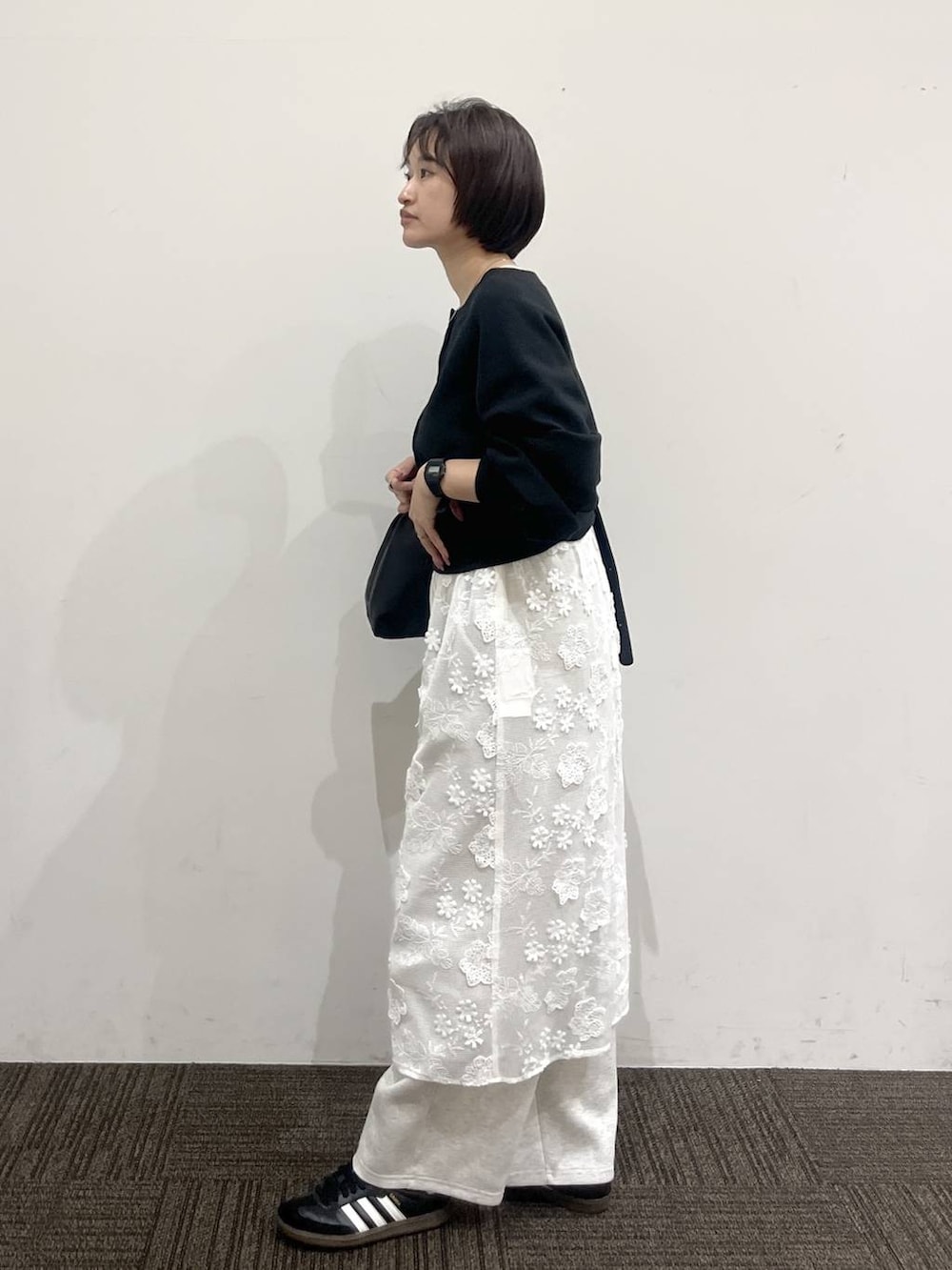 ブラック系のショルダーバッグ、グレー系のスウェットパンツ、ホワイト系のスカートを着用したレディースの春コーディネートの4枚目の写真