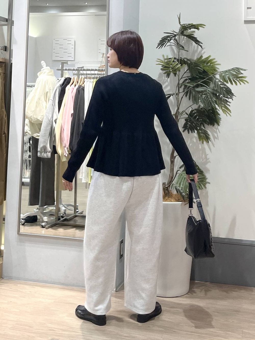 グレー系のスウェットパンツ、ブラック系のショルダーバッグ、ブラック系のローファーを着用したレディースの春コーディネートの4枚目の写真