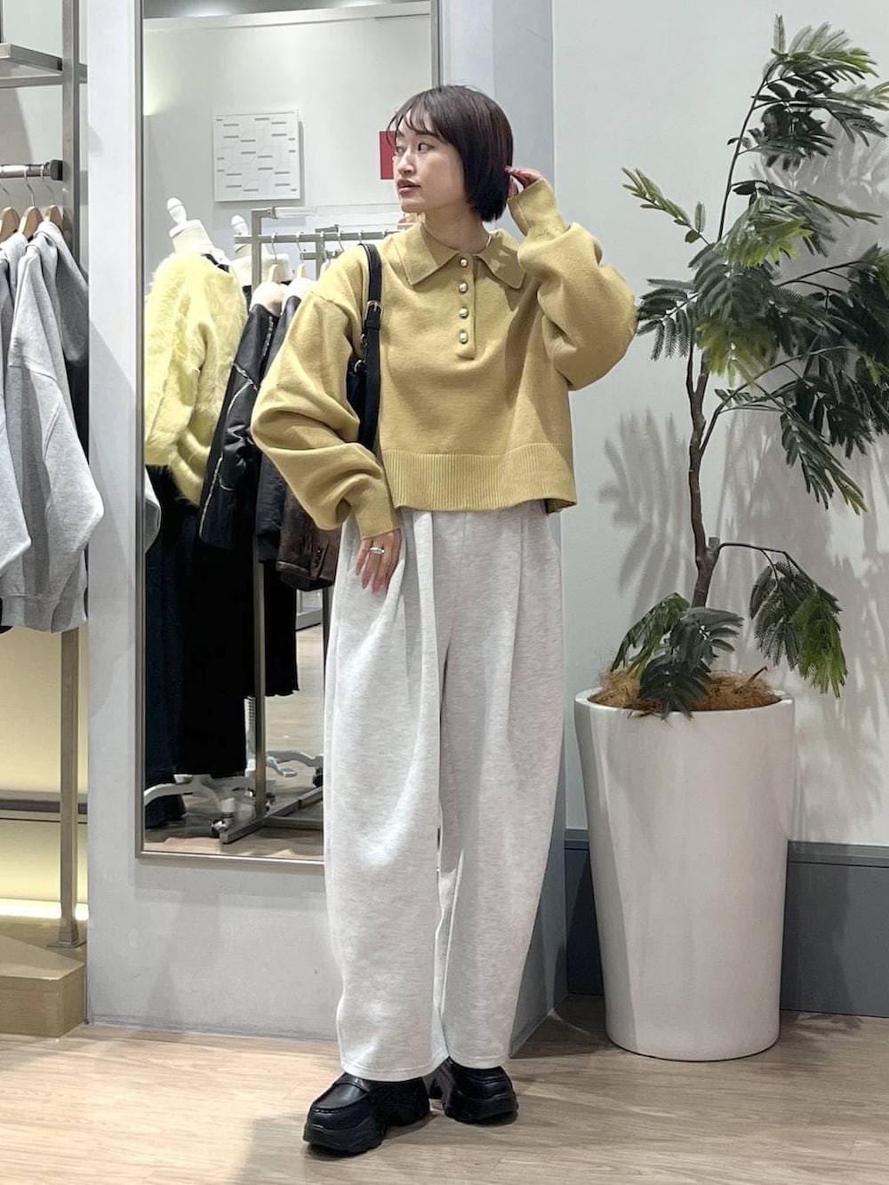 グレー系のスウェットパンツ、ブラック系のショルダーバッグ、ブラック系のローファーを着用したレディースの冬コーディネートの2枚目の写真