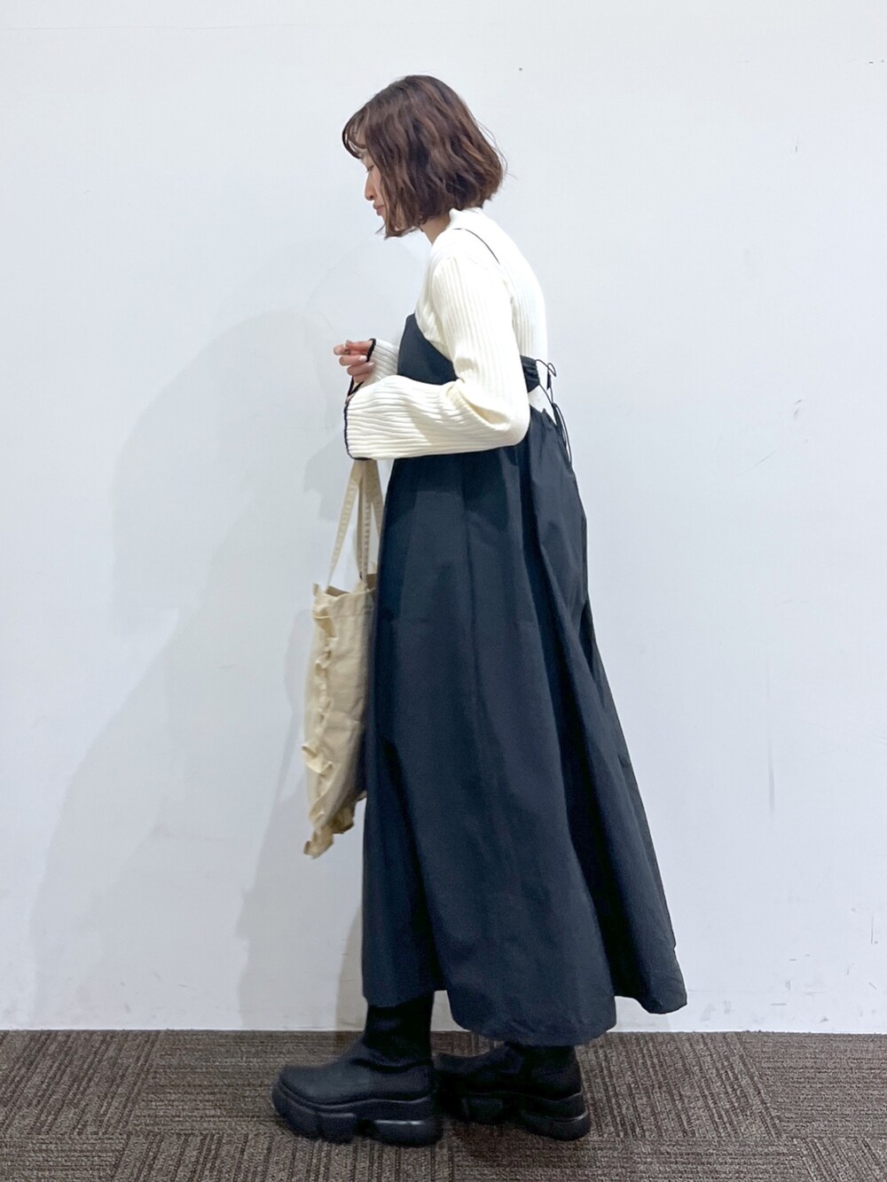 ブラック系のワンピース/ドレス、ホワイト系のトップス、ベージュ系のバッグを着用したレディースの冬コーディネートの2枚目の写真