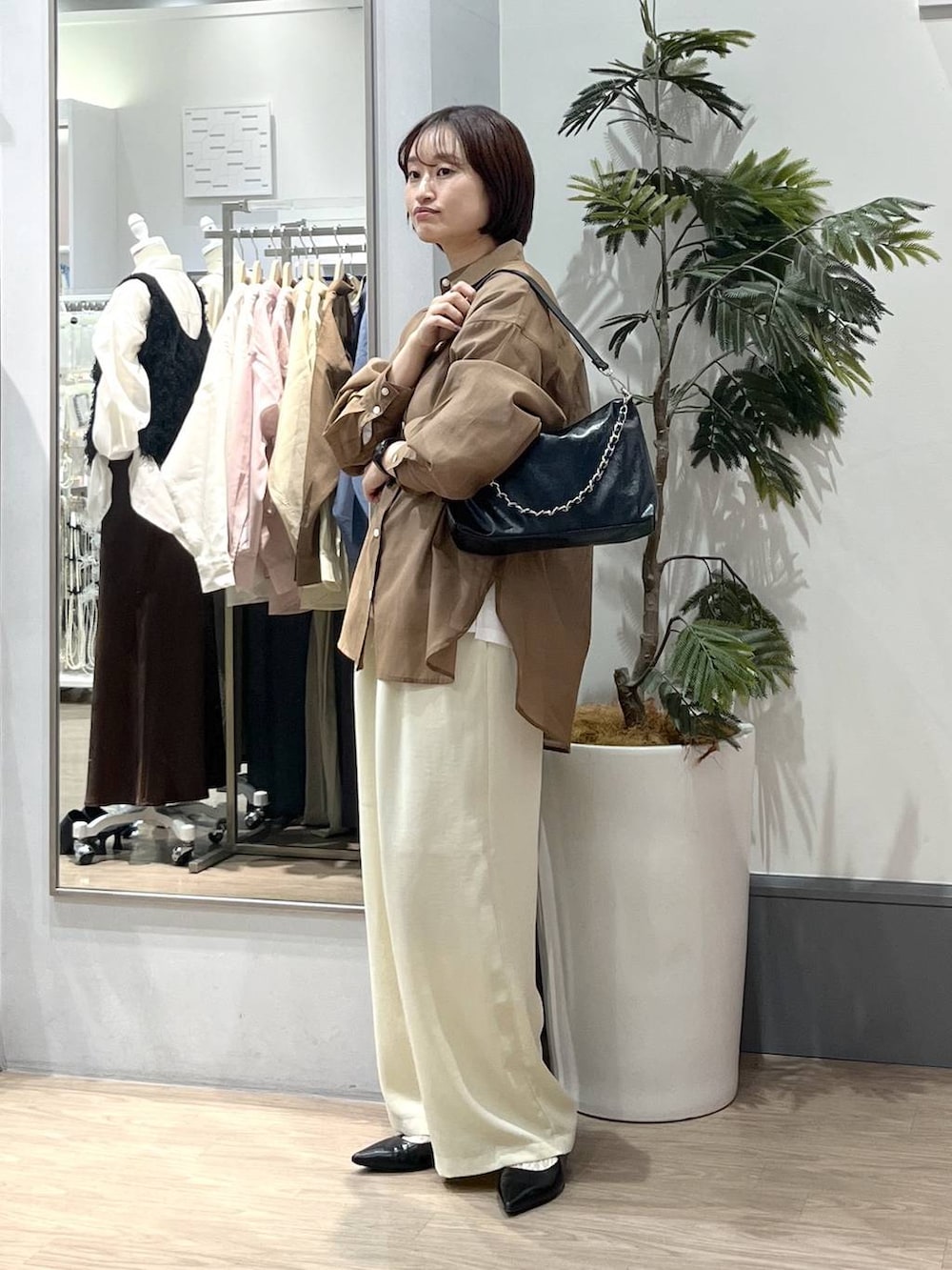 ホワイト系のTシャツ/カットソー、ブラック系のパンプス、ブラウン系のシャツ/ブラウスを着用したレディースの春コーディネートの2枚目の写真