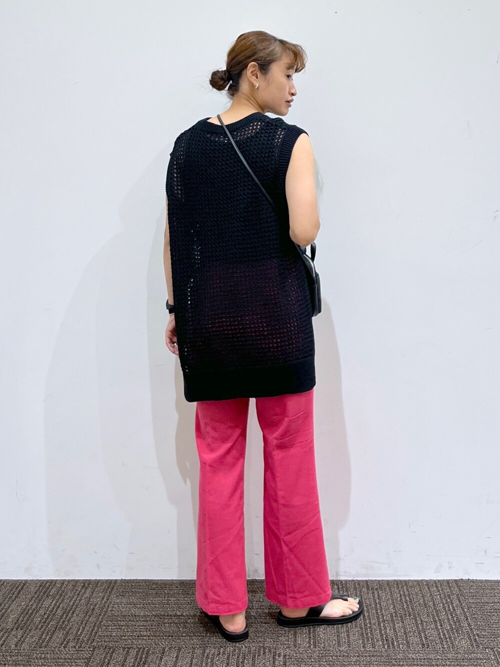 ブラック系のサンダル、ピンク系のスラックス、ブラック系のショルダーバッグを着用したレディースの夏コーディネートの3枚目の写真