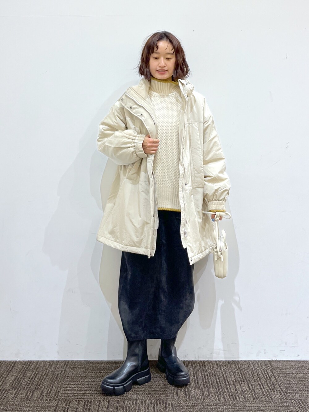 ホワイト系のショルダーバッグ、ブラック系のスカート、ホワイト系のトップスを着用したレディースの秋コーディネートの3枚目の写真