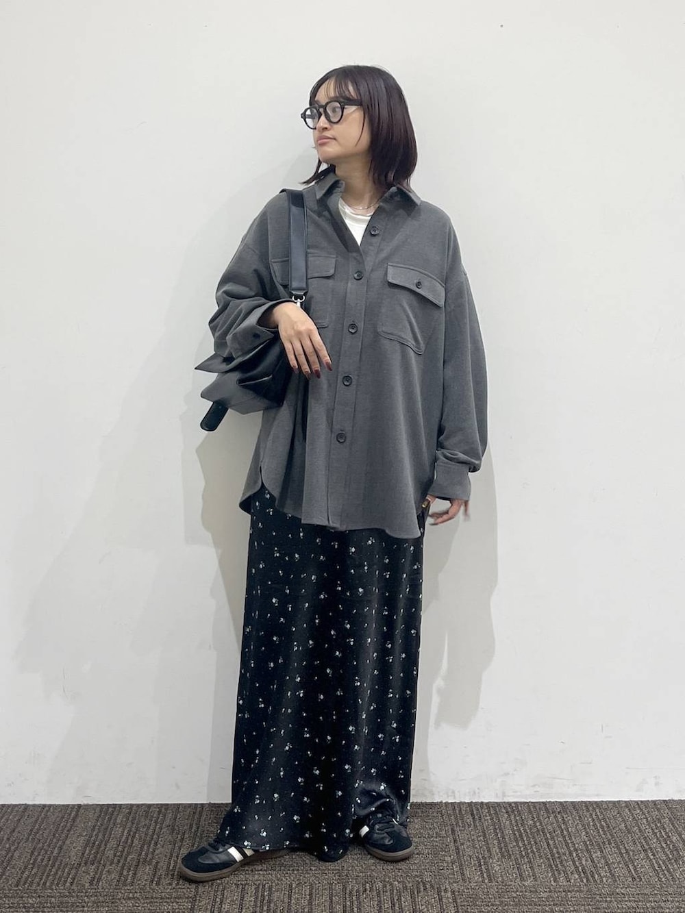 ブラック系のショルダーバッグ、ホワイト系のTシャツ/カットソー、ブラック系のスカートを着用したレディースの秋コーディネートの2枚目の写真