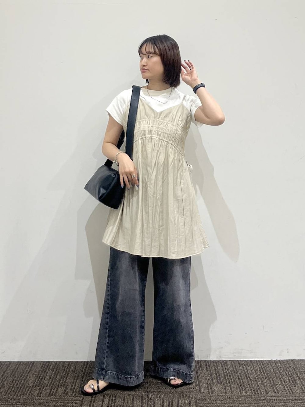 ベージュ系のワンピース、ブラック系のデニムパンツ、ホワイト系のTシャツ/カットソーを着用したレディースの夏コーディネートの2枚目の写真