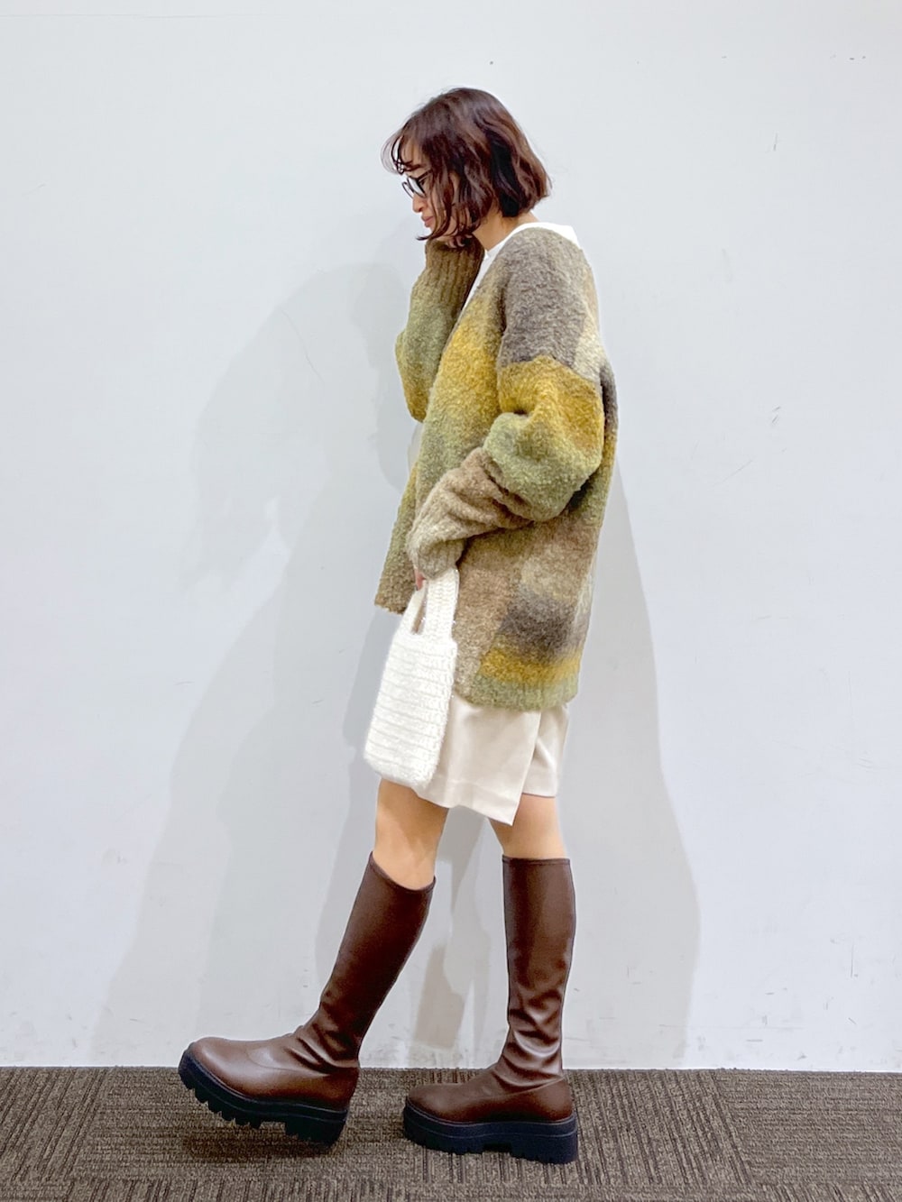 ホワイト系のトートバッグ、イエロー系のトップス、ホワイト系のトップスを着用したレディースの冬コーディネートの2枚目の写真