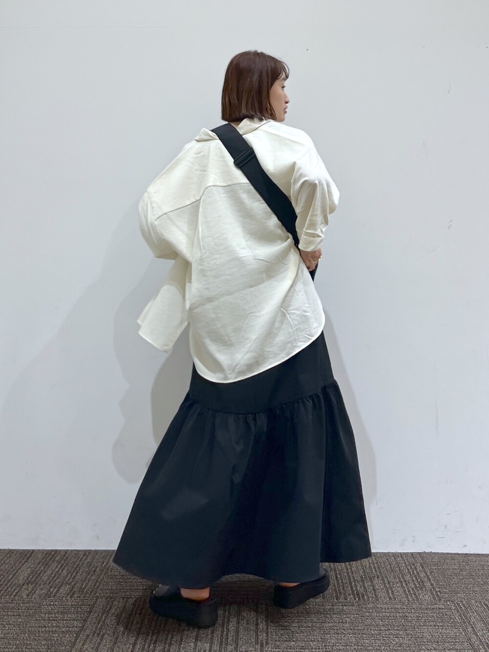 ホワイト系のトップス、ホワイト系のTシャツ/カットソー、ブラック系のスカートを着用したレディースの春コーディネートの2枚目の写真