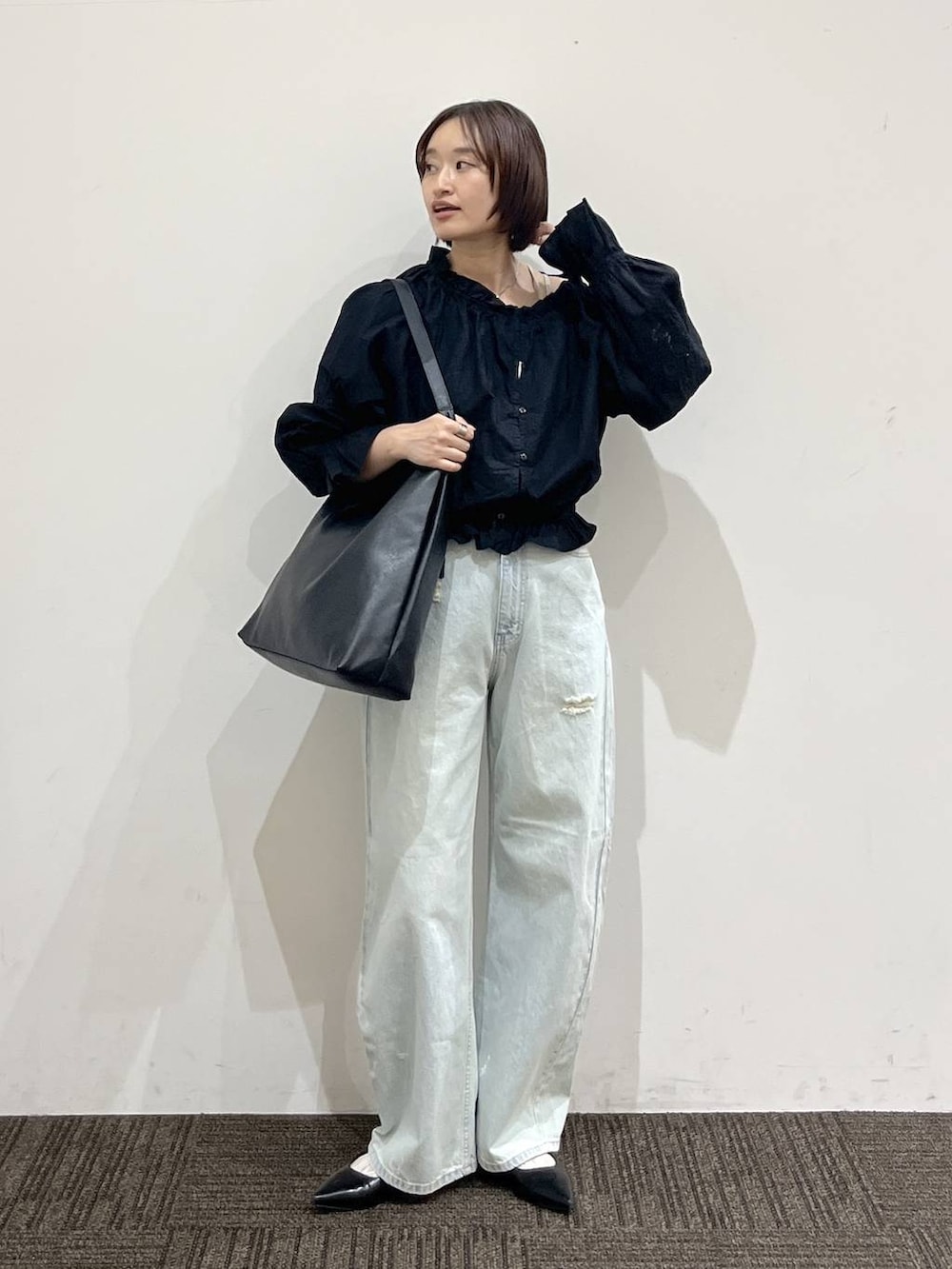 ホワイト系のTシャツ/カットソー、ブラック系のショルダーバッグ、ブラック系のパンプスを着用したレディースの春コーディネートの2枚目の写真