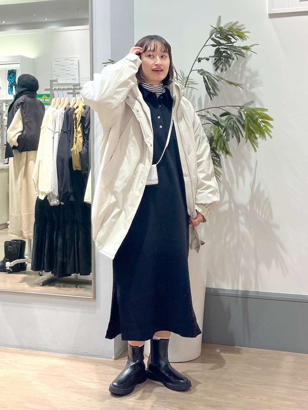 ホワイト系のその他アウター、ブラック系のブーツ、ブラック系のワンピースを着用したレディースの秋コーディネートの2枚目の写真