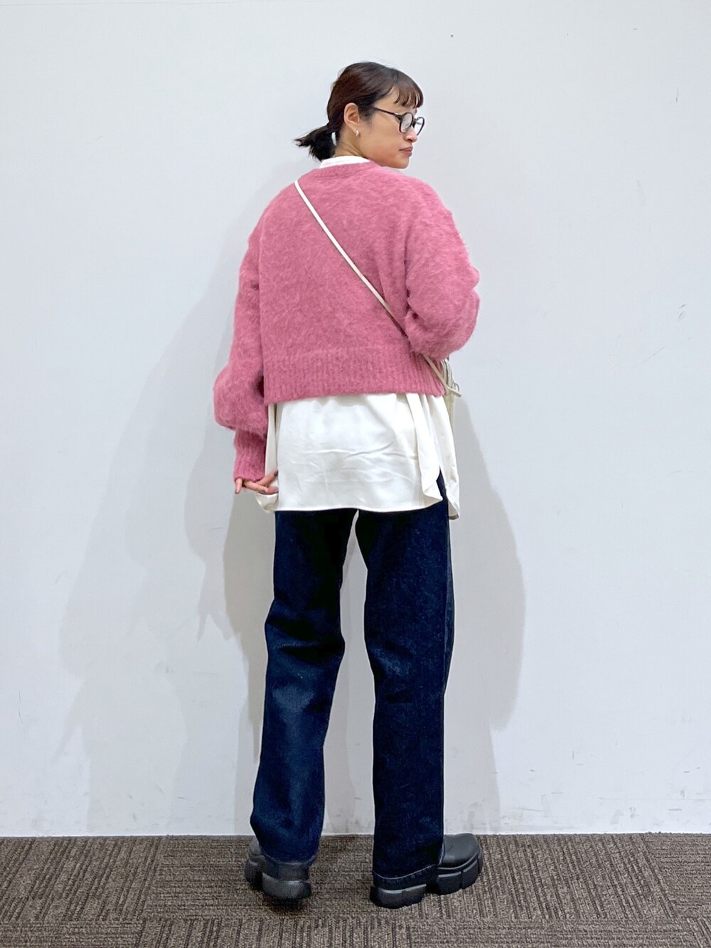 ブラック系のブーツ、ブルー系のパンツ、ホワイト系のシャツ/ブラウスを着用したレディースの冬コーディネートの3枚目の写真