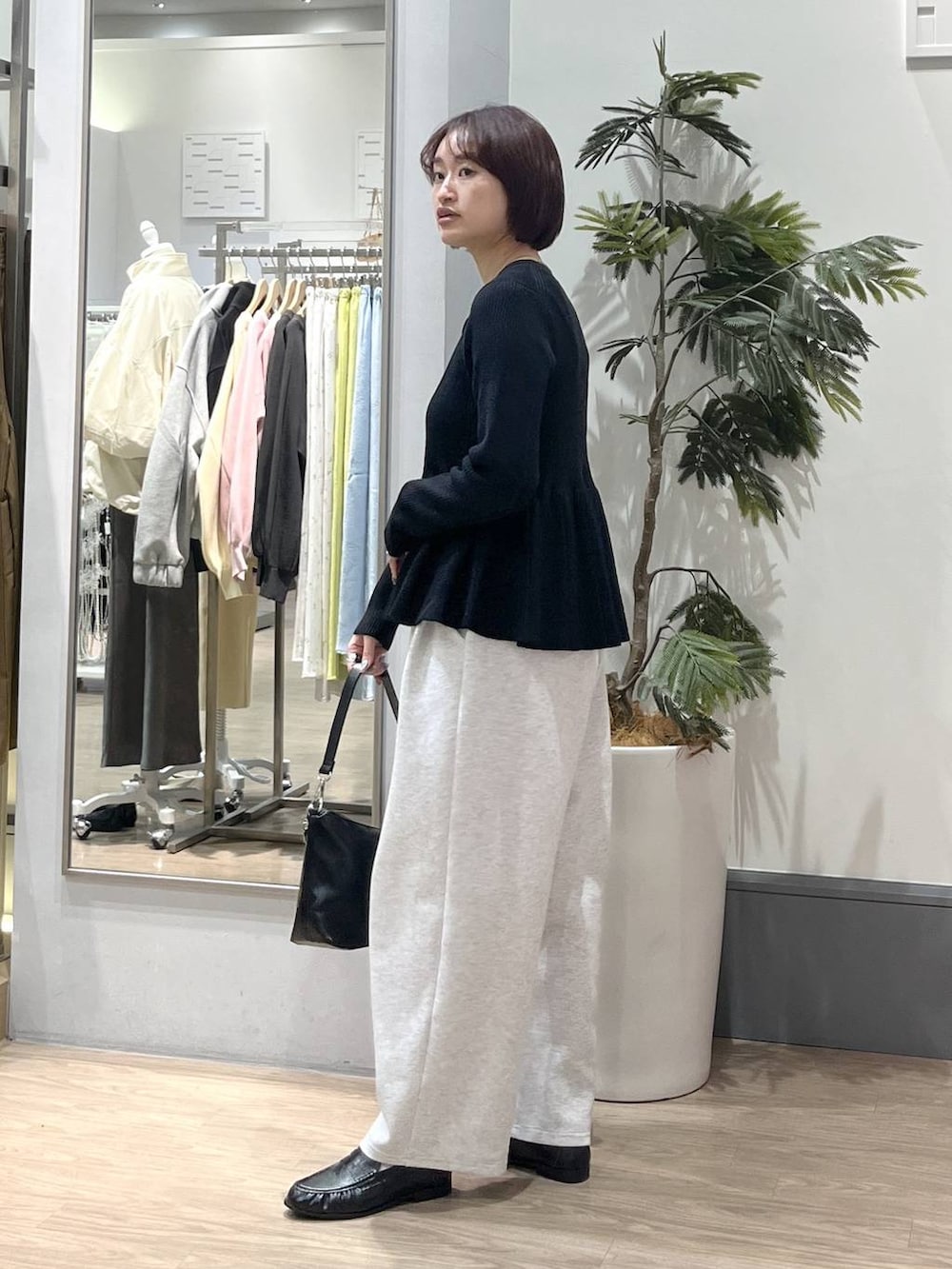 グレー系のスウェットパンツ、ブラック系のショルダーバッグ、ブラック系のローファーを着用したレディースの春コーディネートの3枚目の写真