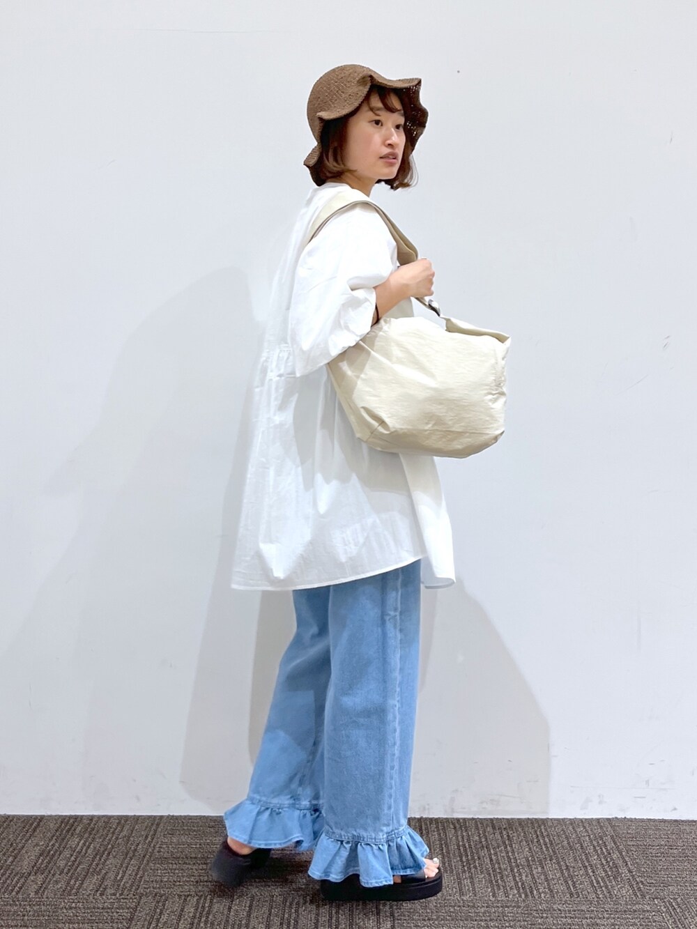 ホワイト系のバッグ、ブルー系のデニムパンツ、ホワイト系のシャツ/ブラウスを着用したレディースの春コーディネートの3枚目の写真