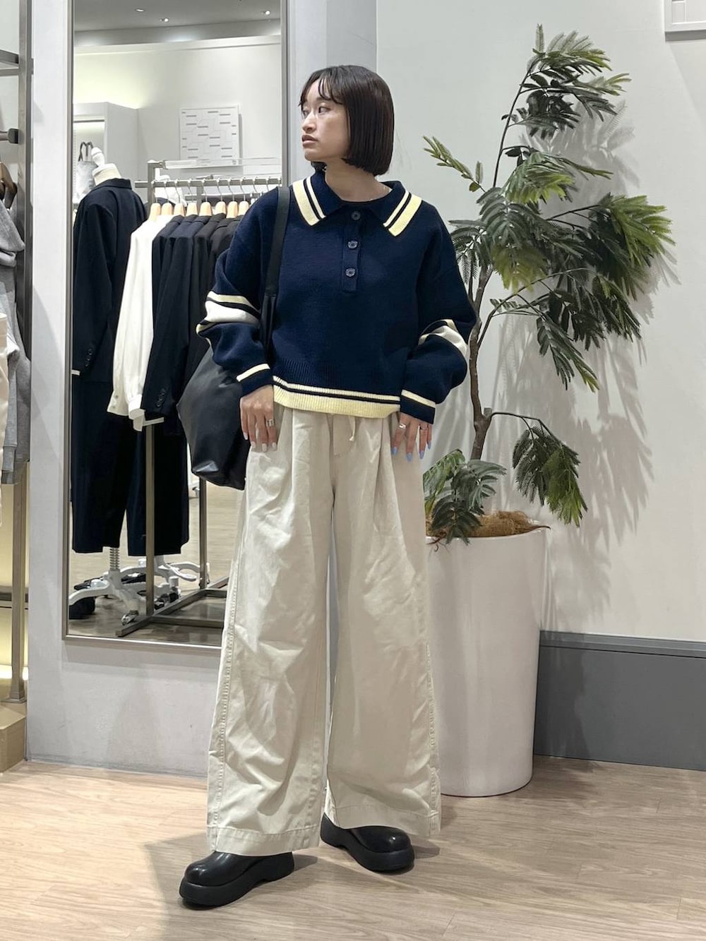 ブラック系のショルダーバッグ、ブラック系のTシャツ/カットソー、ホワイト系のデニムパンツを着用したレディースの冬コーディネートの2枚目の写真