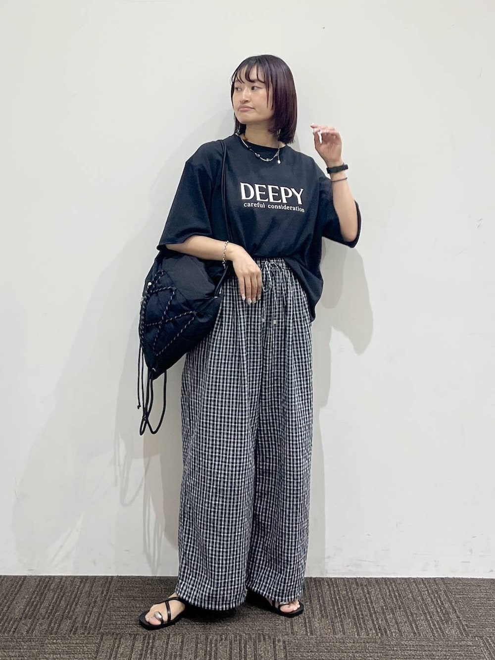 ブラック系のTシャツ/カットソー、ブラック系のサンダル、ブラック系のバックパック/リュックを着用したレディースの夏コーディネートの2枚目の写真