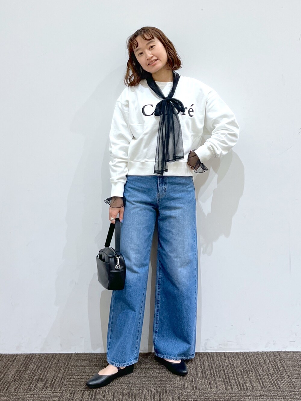 ブラック系のトップス、ホワイト系のトップス、ブルー系のパンツを着用したレディースの冬コーディネートの2枚目の写真