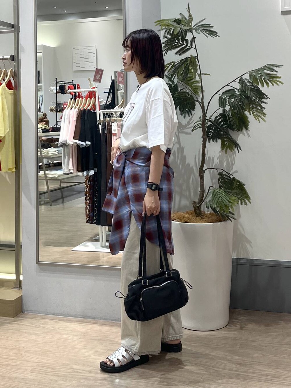 ベージュ系のデニムパンツ、シルバー系のサンダル、ブラック系のボストンバッグを着用したレディースの夏コーディネートの3枚目の写真