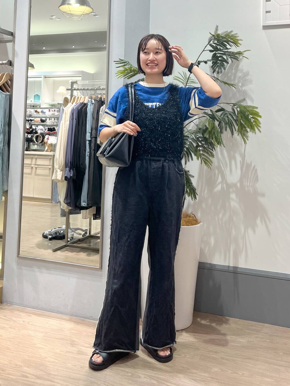 ブラック系のデニムパンツ、ブラック系のサンダル、ブラック系のキャミソールを着用したレディースの夏コーディネートの2枚目の写真