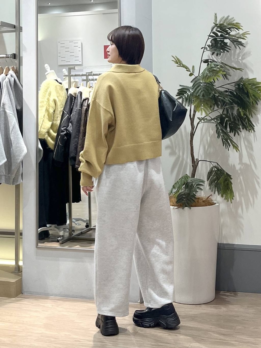 グレー系のスウェットパンツ、ブラック系のショルダーバッグ、ブラック系のローファーを着用したレディースの冬コーディネートの4枚目の写真