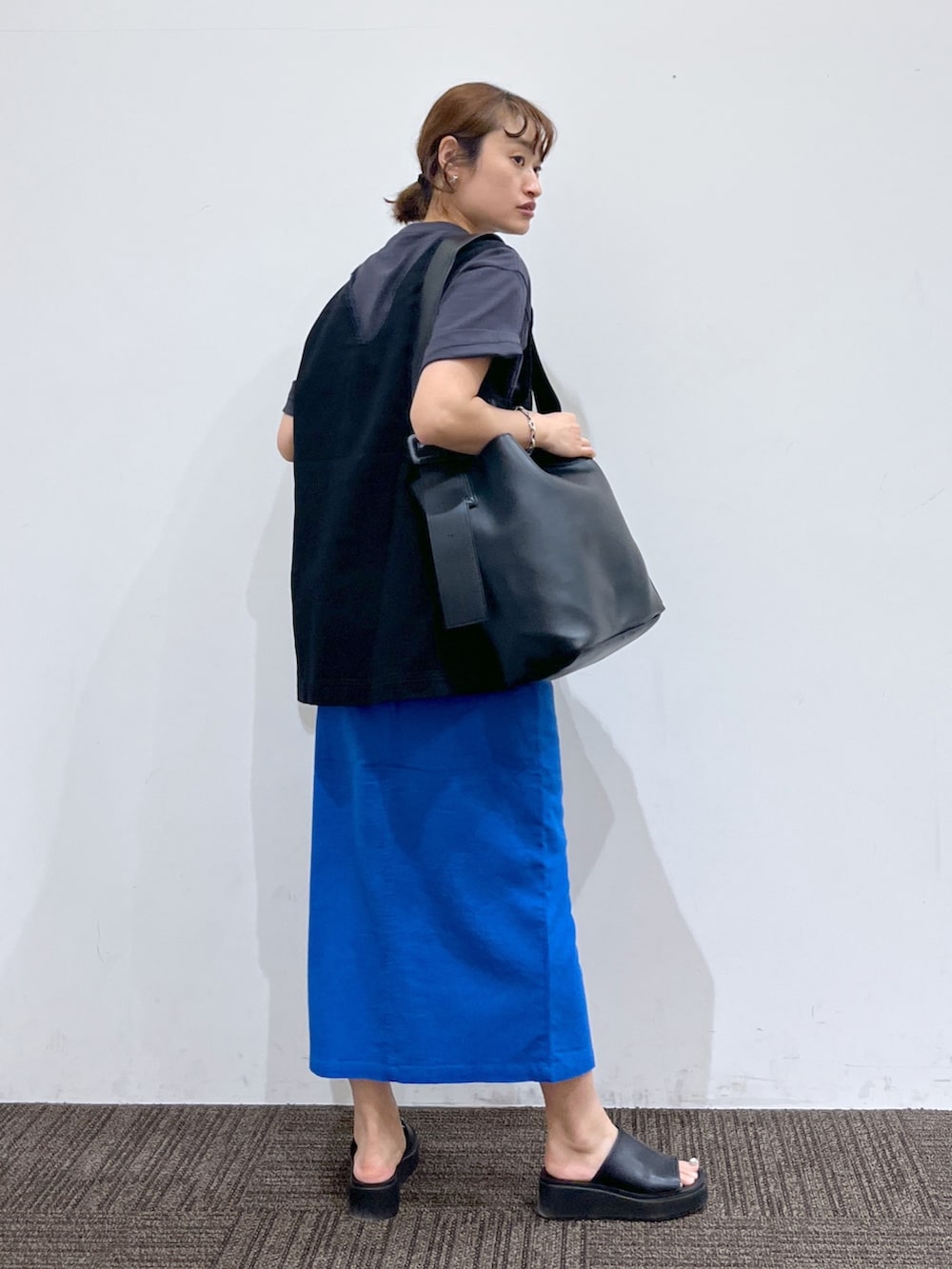 グレー系のTシャツ/カットソー、ブラック系のベスト、ブラック系のシューズを着用したレディースの夏コーディネートの3枚目の写真