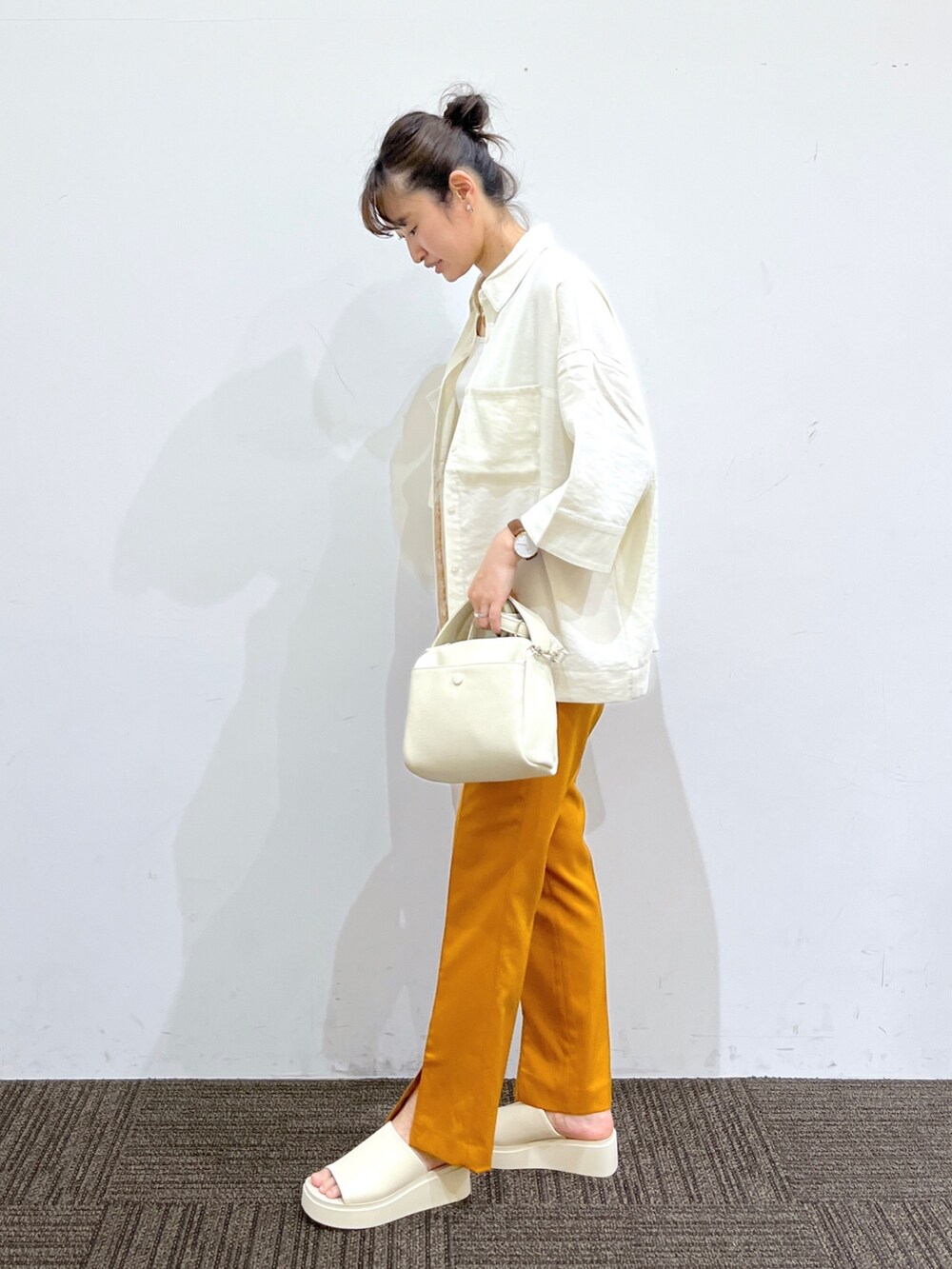 ホワイト系のサンダル、オレンジ系のその他パンツ、ホワイト系のショルダーバッグを着用したレディースの春コーディネートの2枚目の写真