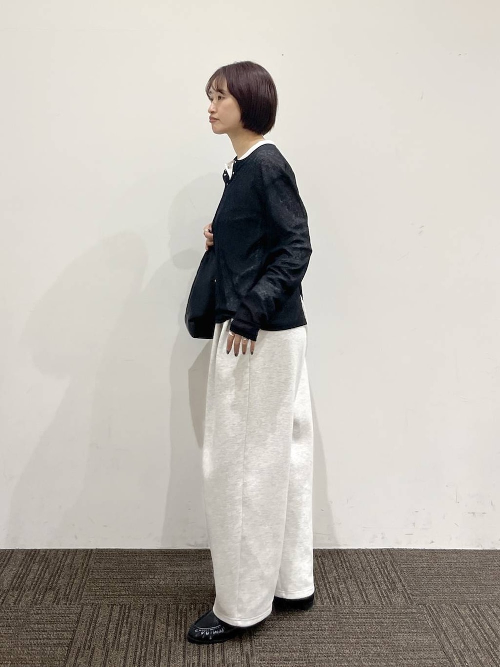 ブラック系のショルダーバッグ、グレー系のスウェットパンツ、ブラック系のローファーを着用したレディースの春コーディネートの3枚目の写真