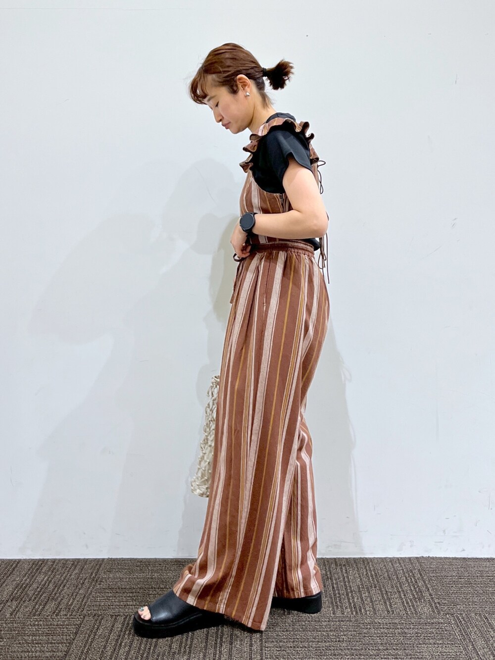 ブラック系のシューズ、ホワイト系のバッグ、ブラウン系のその他パンツを着用したレディースの春コーディネートの2枚目の写真