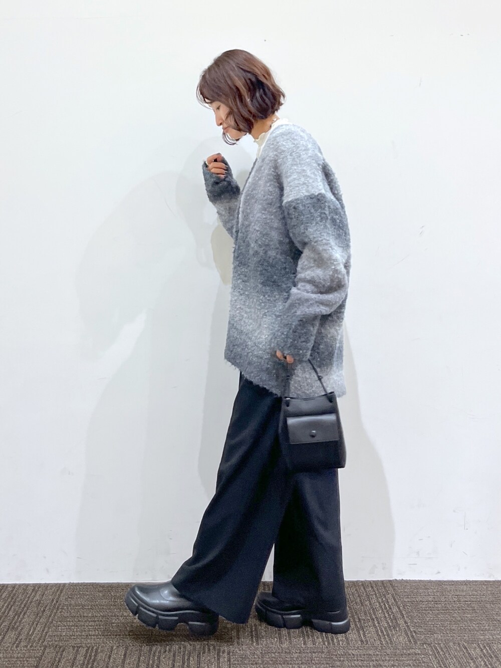 ホワイト系のニット/セーター、ブラック系のトップス、ブラック系のパンツを着用したレディースの冬コーディネートの2枚目の写真