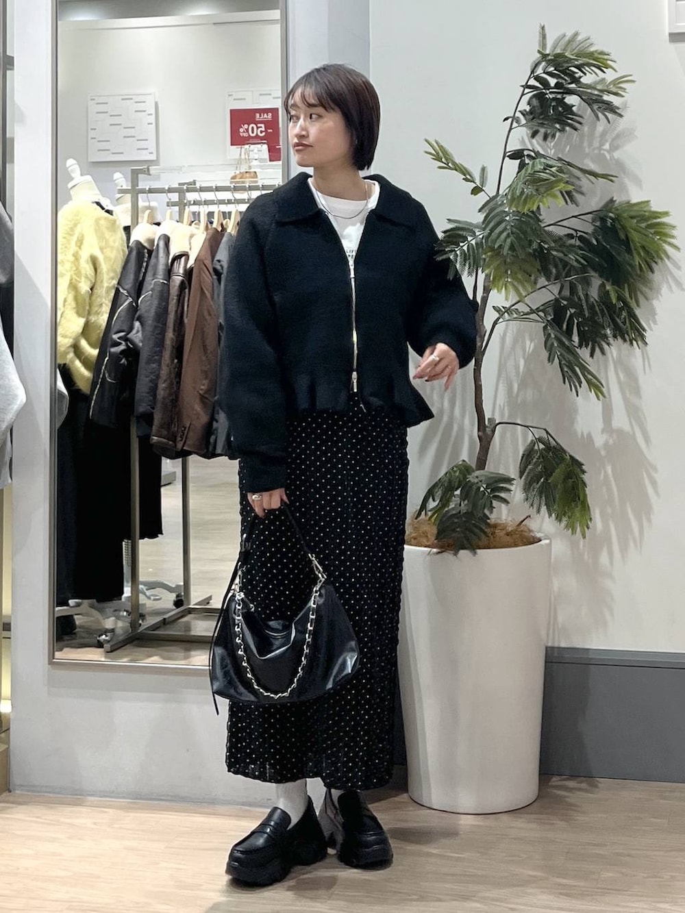 ブラック系のショルダーバッグ、ブラック系のローファー、ブラック系のスカートを着用したレディースの冬コーディネートの3枚目の写真