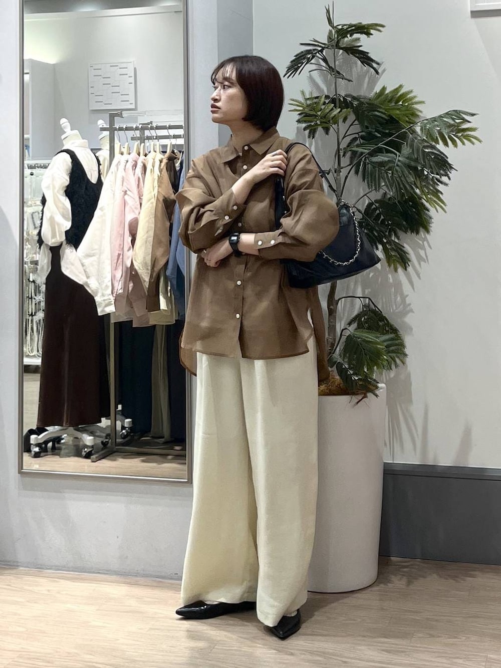 ホワイト系のTシャツ/カットソー、ブラック系のパンプス、ブラウン系のシャツ/ブラウスを着用したレディースの春コーディネートの3枚目の写真