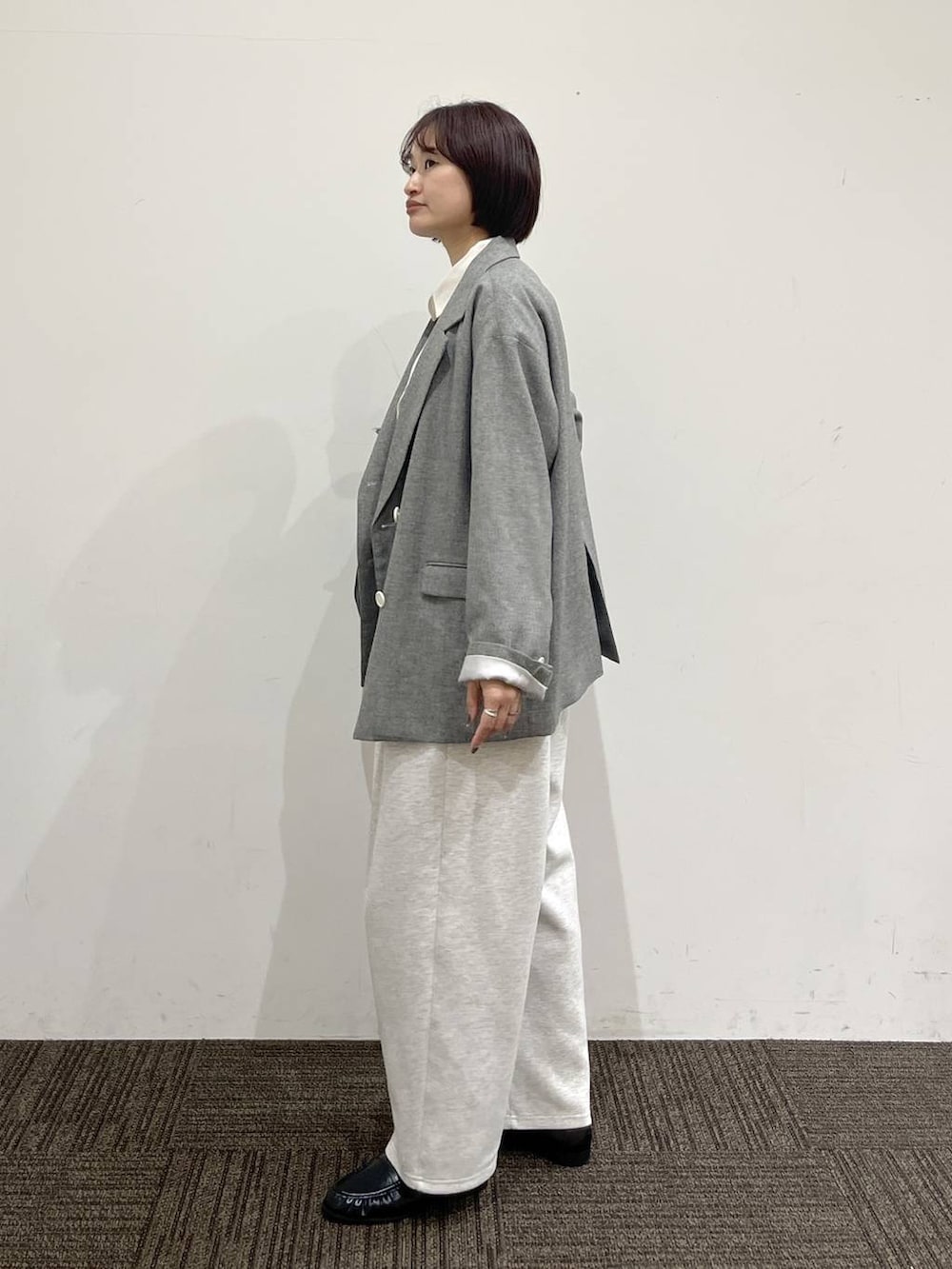 ブラック系のショルダーバッグ、グレー系のスウェットパンツ、グレー系のテーラードジャケットを着用したレディースの春コーディネートの4枚目の写真