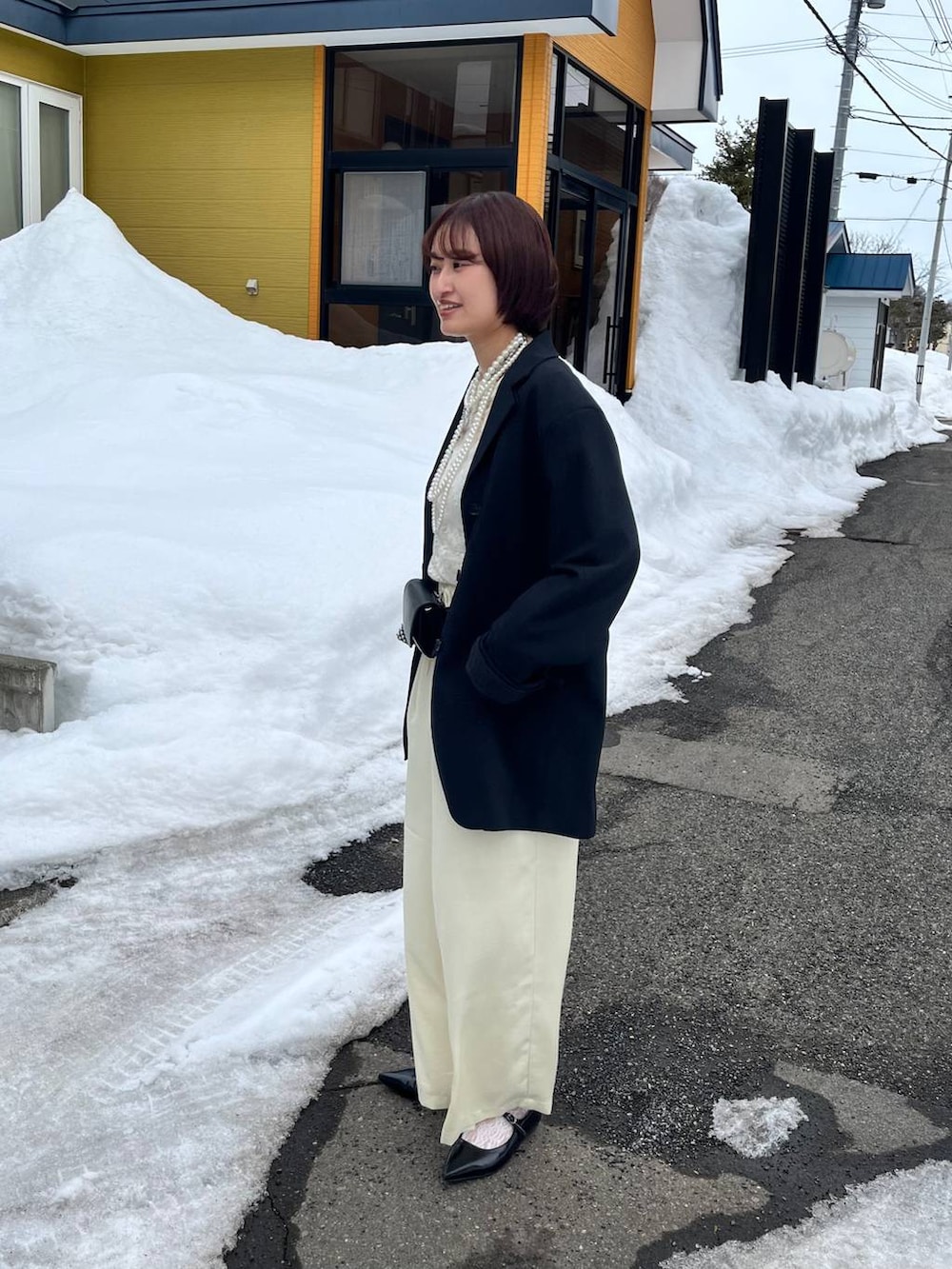 ブラック系のパンプス、イエロー系のその他パンツ、ブラック系のボディバッグ/ウエストポーチを着用したレディースの春コーディネートの3枚目の写真