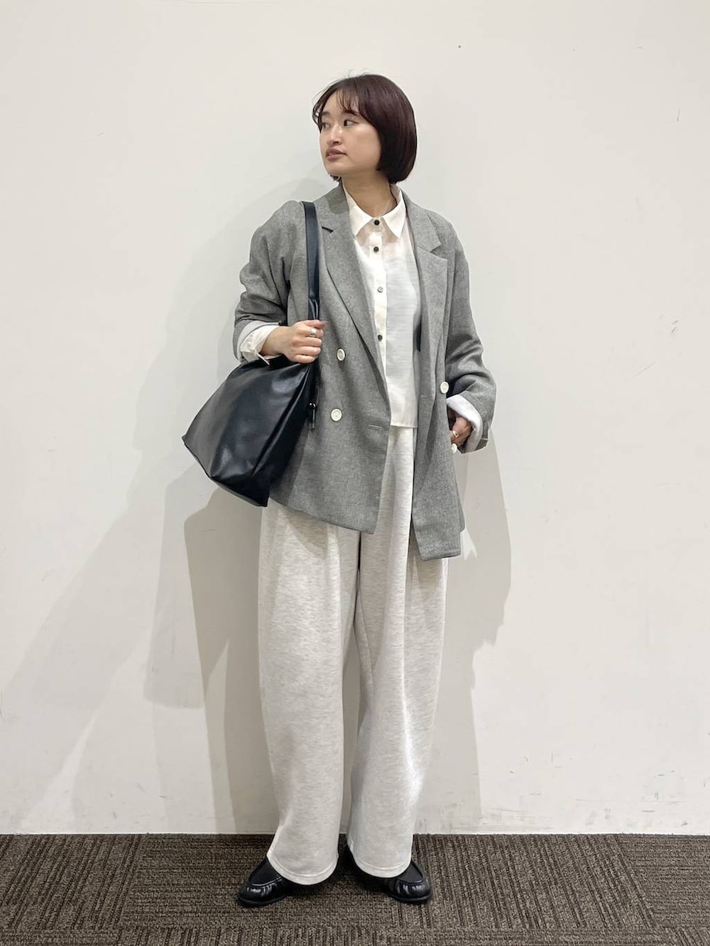 ブラック系のショルダーバッグ、グレー系のスウェットパンツ、グレー系のテーラードジャケットを着用したレディースの春コーディネートの2枚目の写真