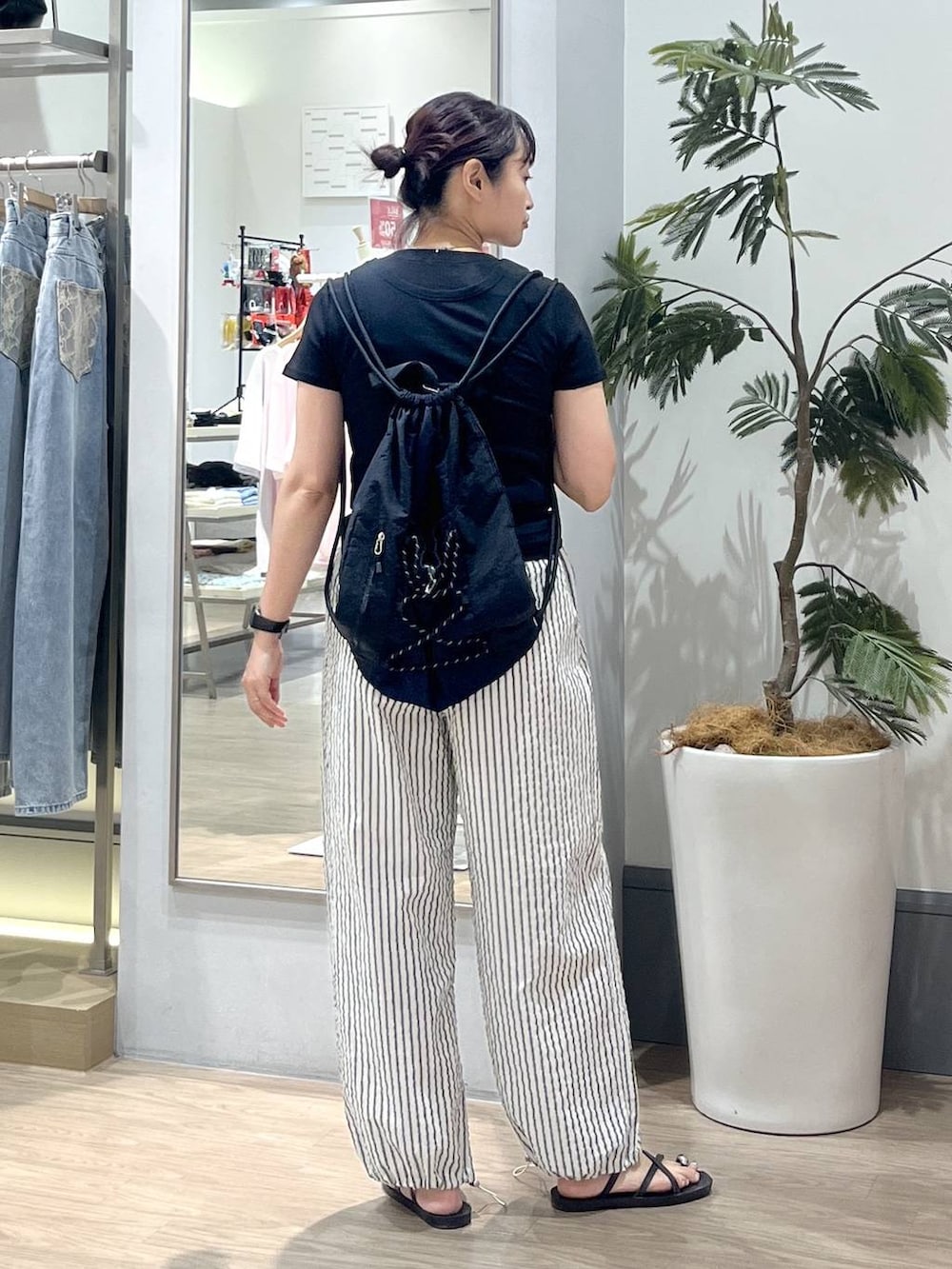 ブラック系のTシャツ/カットソー、ブラック系のサンダル、ブラック系のバックパック/リュックを着用したレディースの夏コーディネートの4枚目の写真
