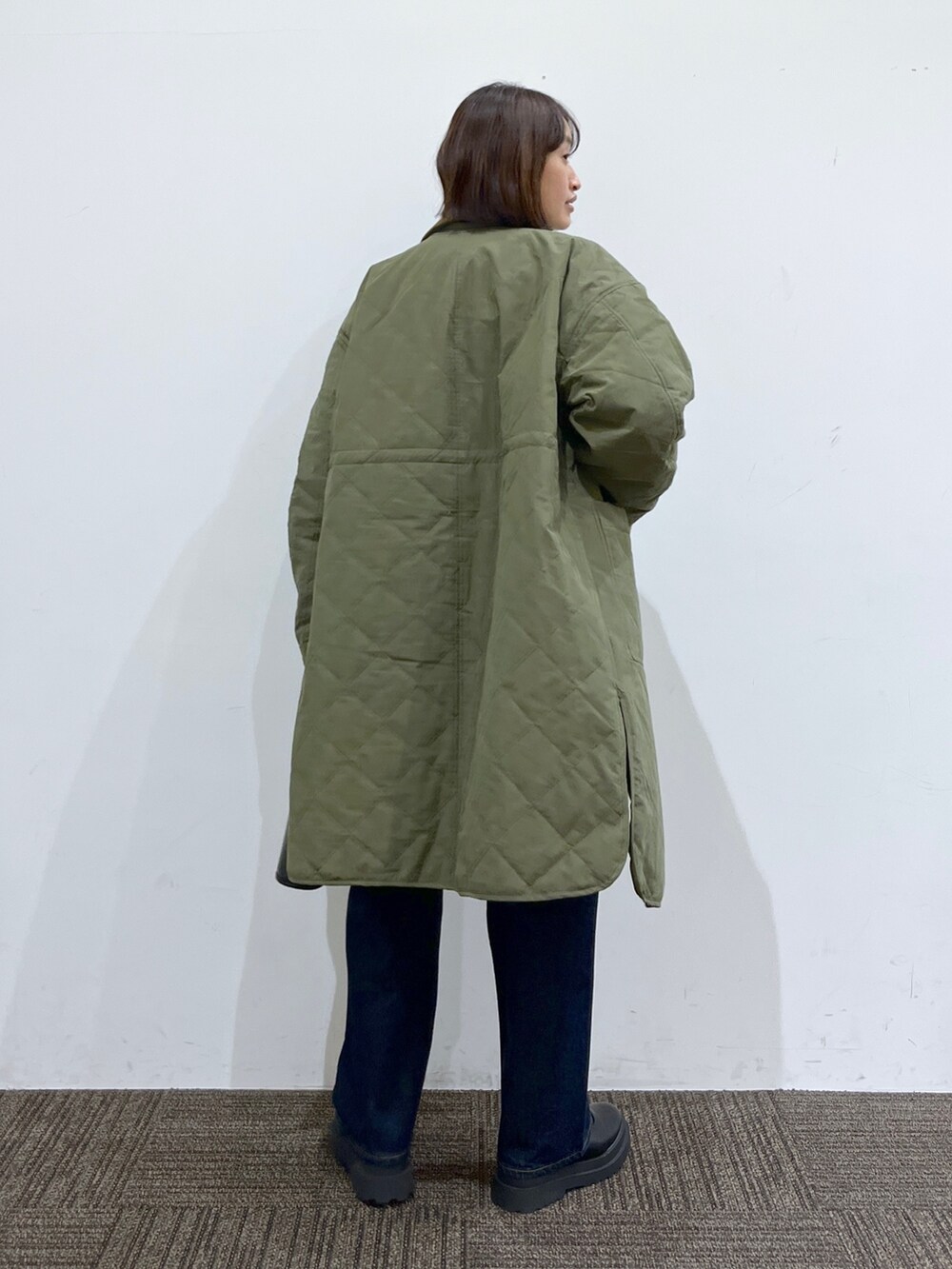 グレー系のトップス、グリーン系のジャケット/アウター、ブルー系のパンツを着用したレディースの秋コーディネートの3枚目の写真