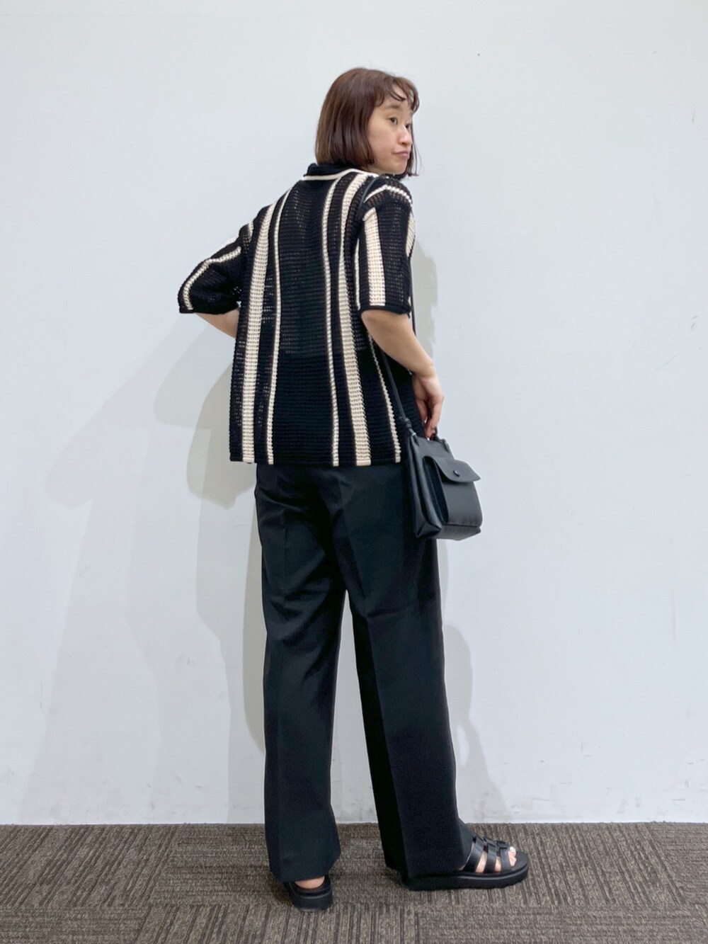 ブラック系のトップス、ホワイト系のトップス、ブラック系のパンツを着用したレディースの春コーディネートの3枚目の写真