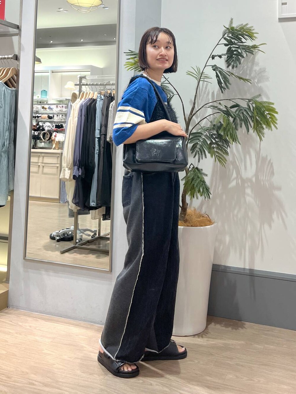 ブラック系のデニムパンツ、ブラック系のサンダル、ブラック系のキャミソールを着用したレディースの夏コーディネートの4枚目の写真