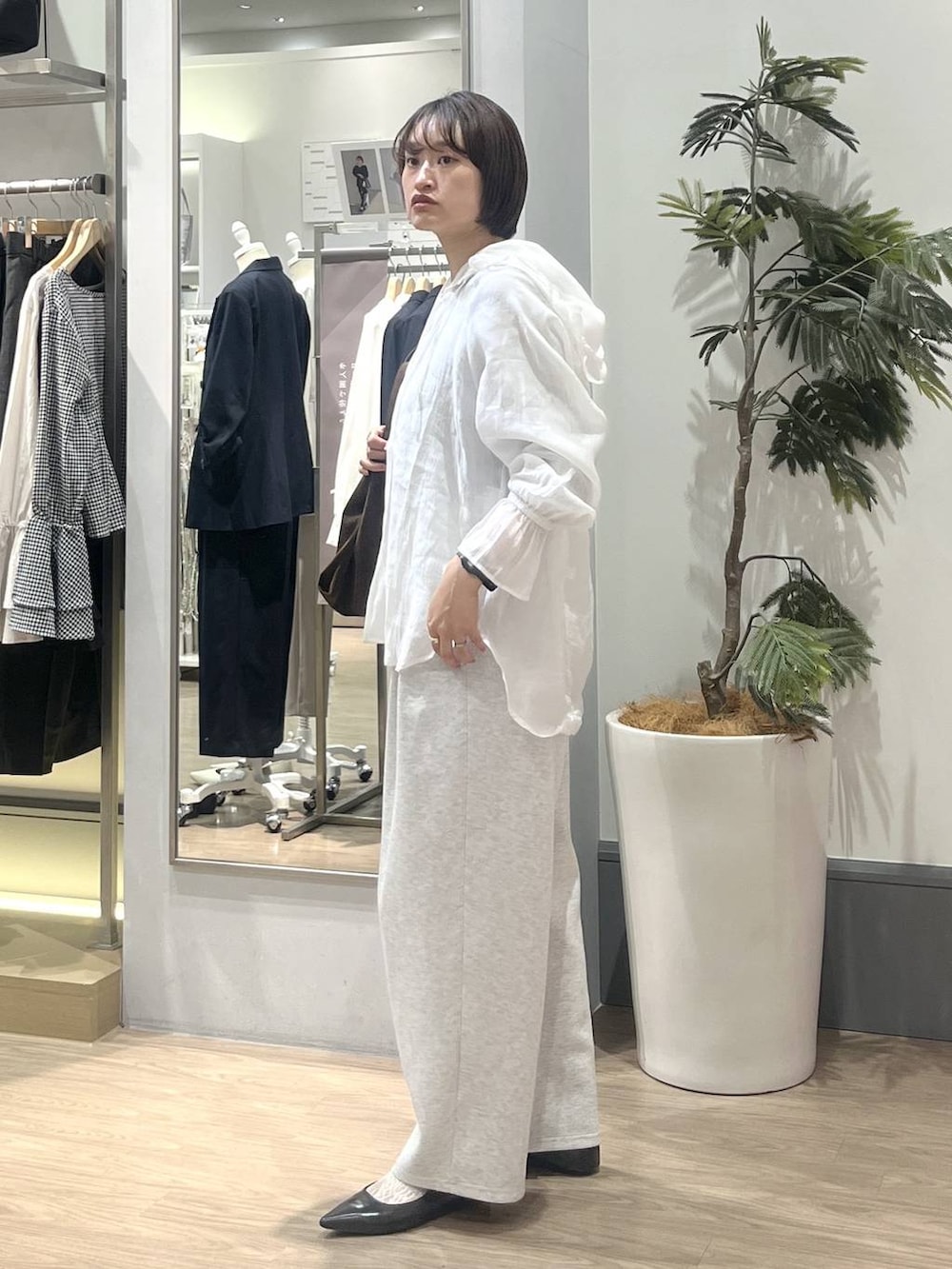 グレー系のスウェットパンツ、ホワイト系のシャツ/ブラウス、ブラック系のパンプスを着用したレディースの冬コーディネートの4枚目の写真