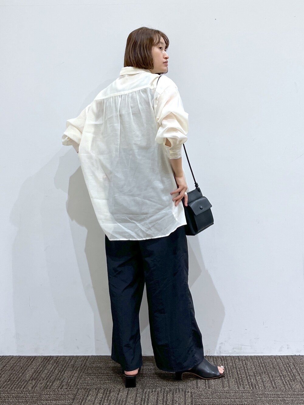 ブラック系のパンツ、ブラック系のトップス、ホワイト系のトップスを着用したレディースの春コーディネートの4枚目の写真