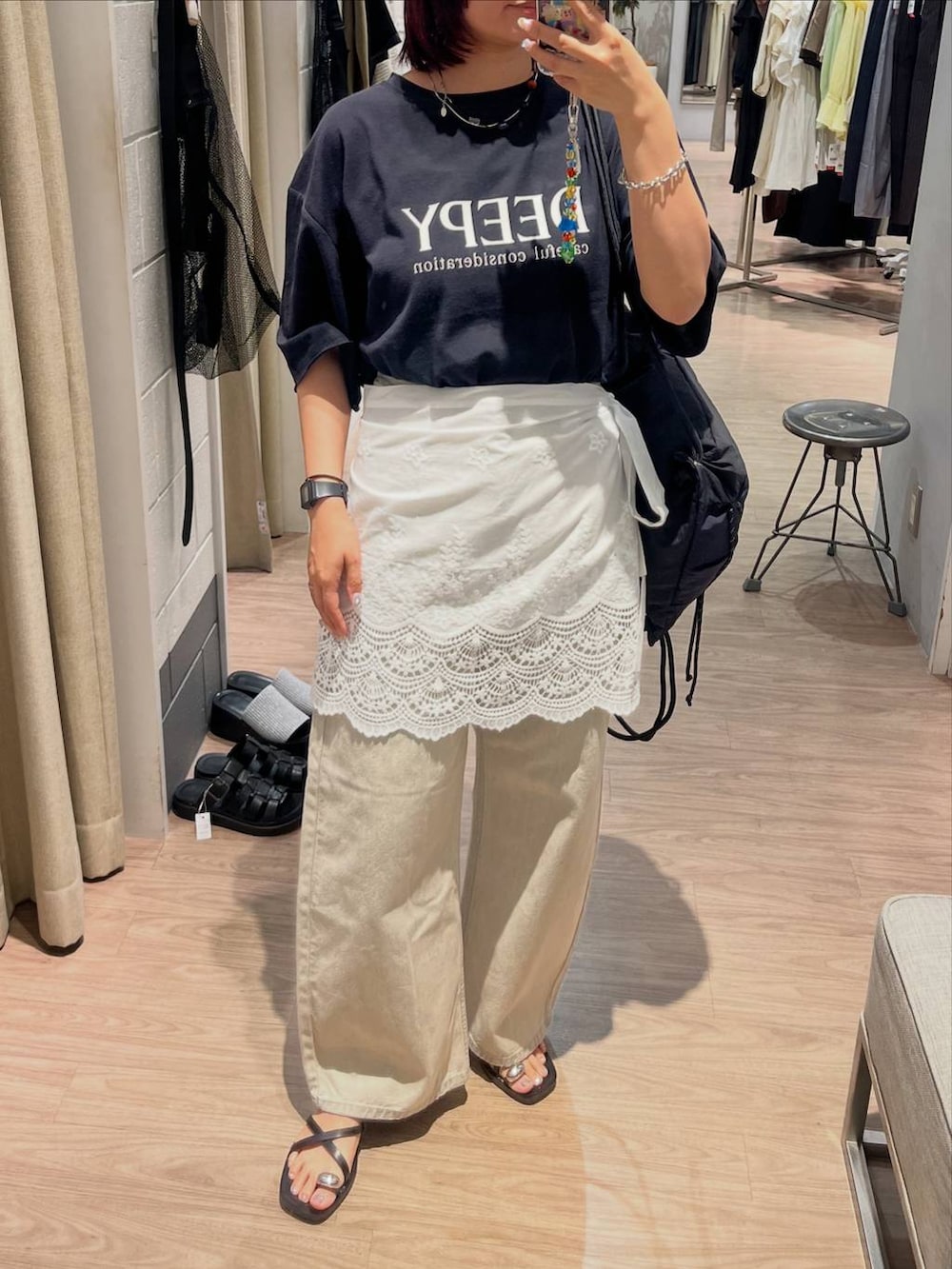 ブラック系のTシャツ/カットソー、ベージュ系のデニムパンツ、ブラック系のサンダルを着用したレディースの夏コーディネートの4枚目の写真