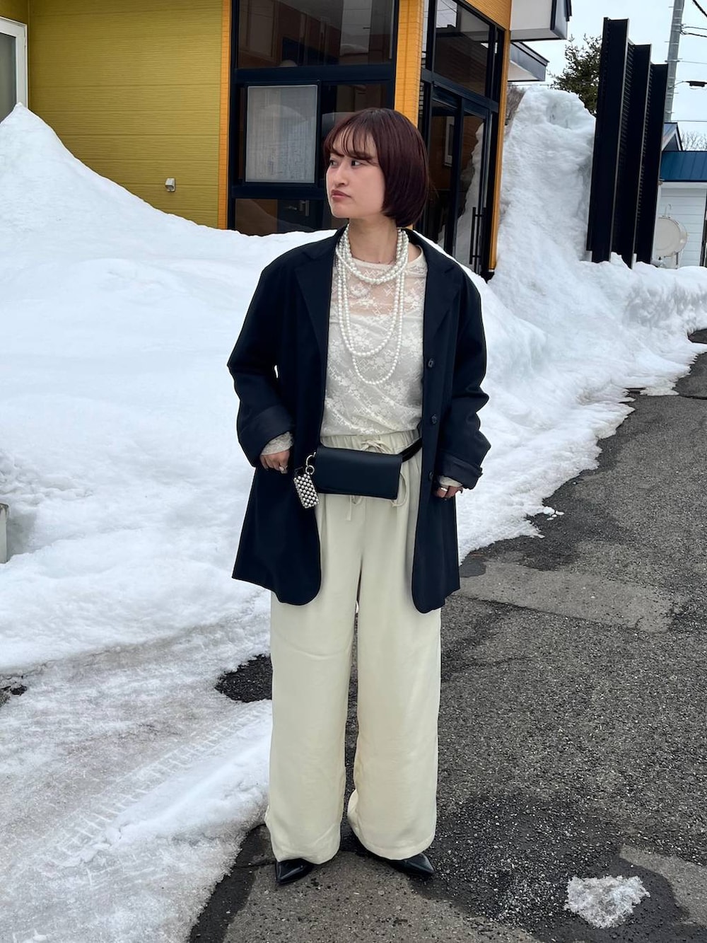 ブラック系のパンプス、イエロー系のその他パンツ、ブラック系のボディバッグ/ウエストポーチを着用したレディースの春コーディネートの2枚目の写真