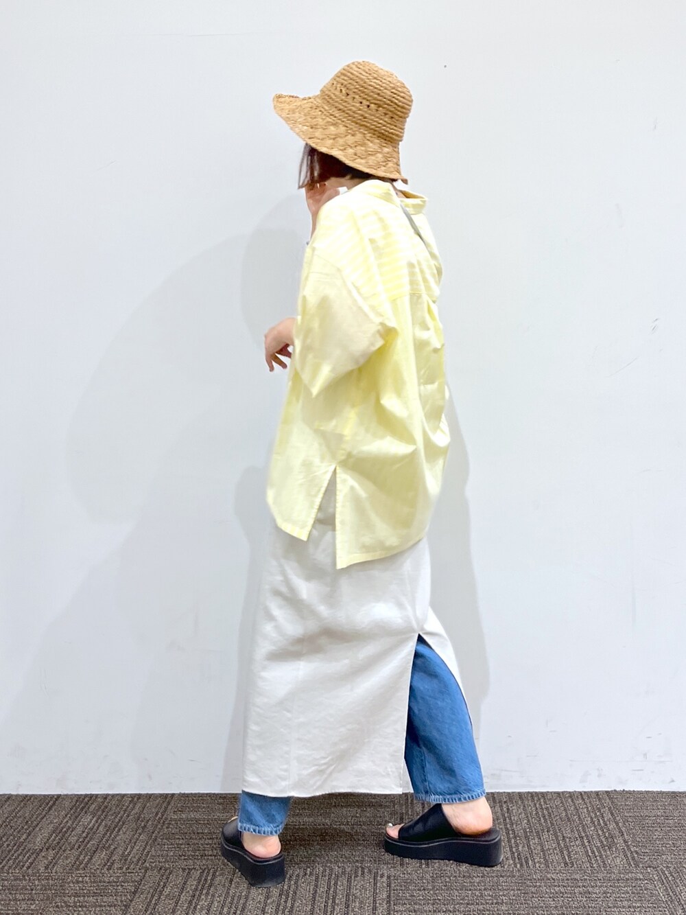 ホワイト系のワンピース、イエロー系のシャツ/ブラウス、ブルー系のデニムパンツを着用したレディースの夏コーディネートの3枚目の写真