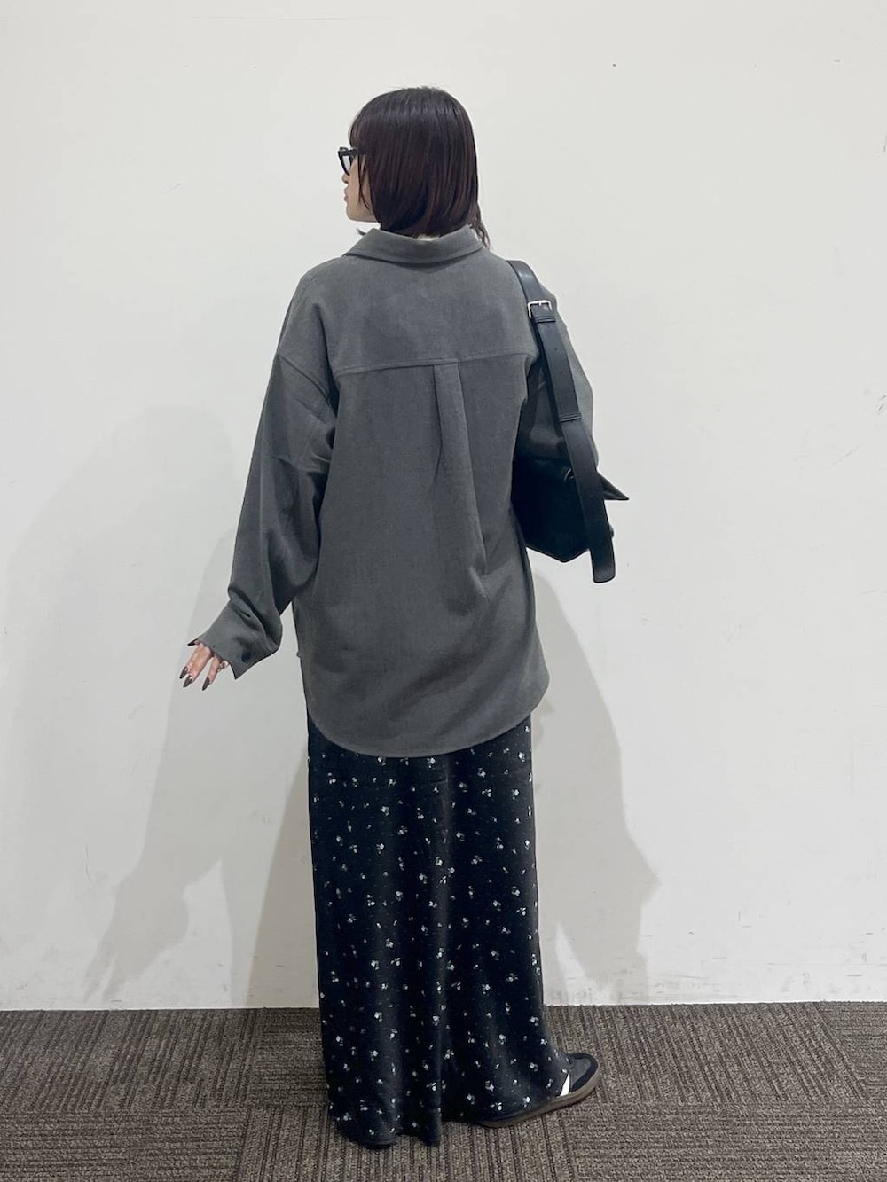ブラック系のショルダーバッグ、ホワイト系のTシャツ/カットソー、ブラック系のスカートを着用したレディースの秋コーディネートの4枚目の写真