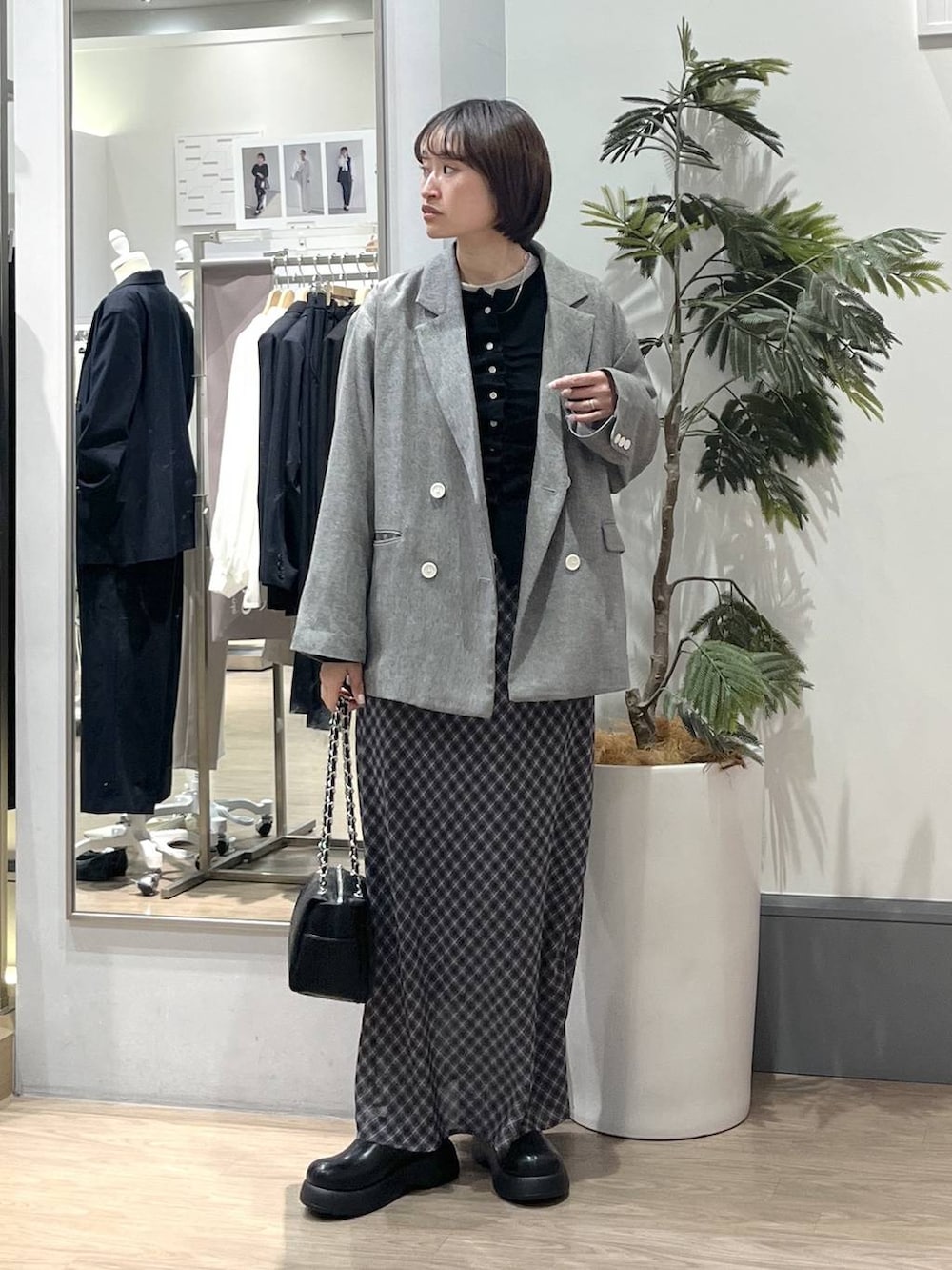 グレー系のテーラードジャケット、ブラック系のショルダーバッグ、ブラック系のサンダルを着用したレディースの春コーディネートの2枚目の写真