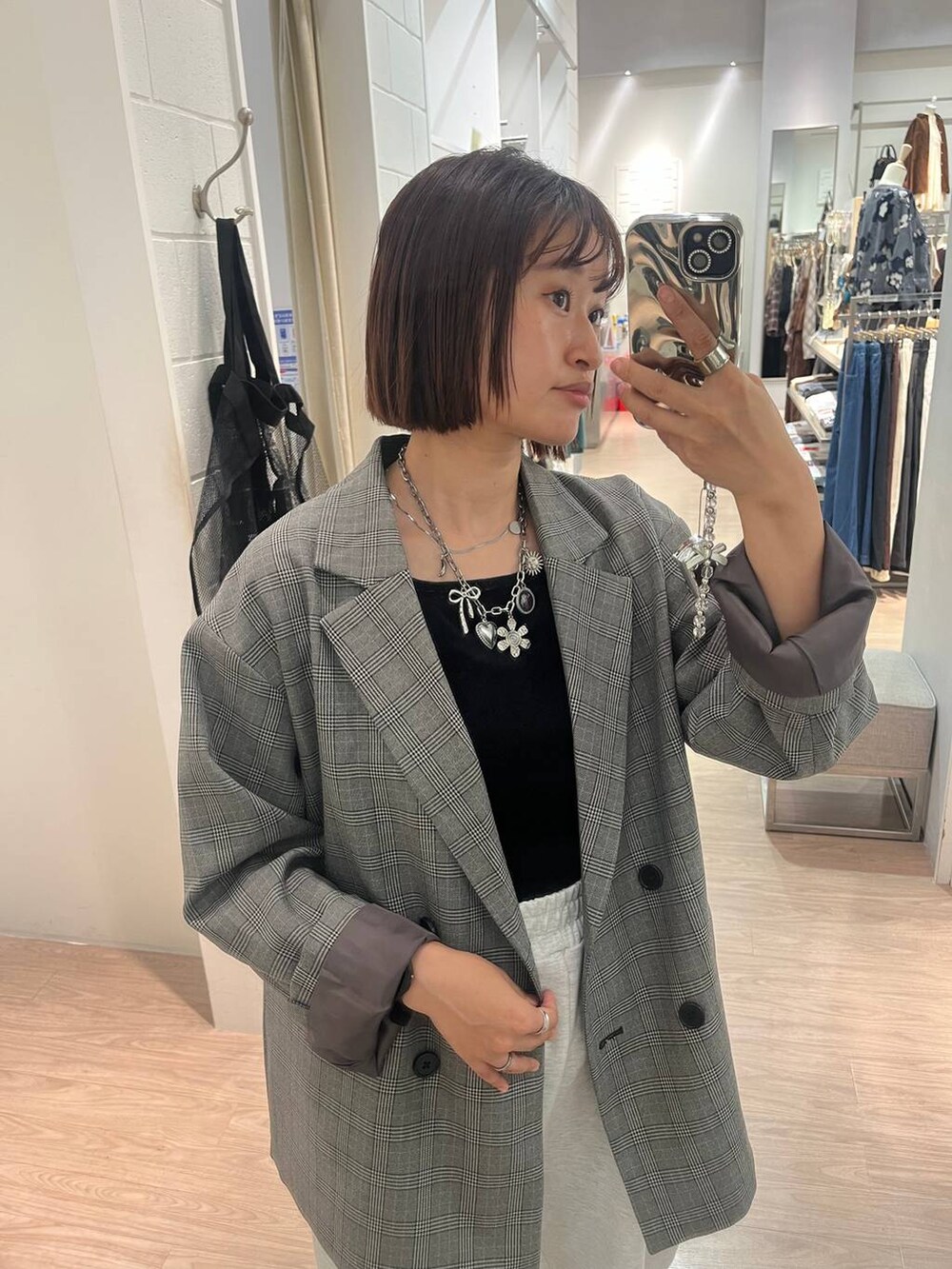 グレー系のスウェットパンツ、グレー系のテーラードジャケット、ブラック系のタンクトップを着用したレディースの秋コーディネートの2枚目の写真